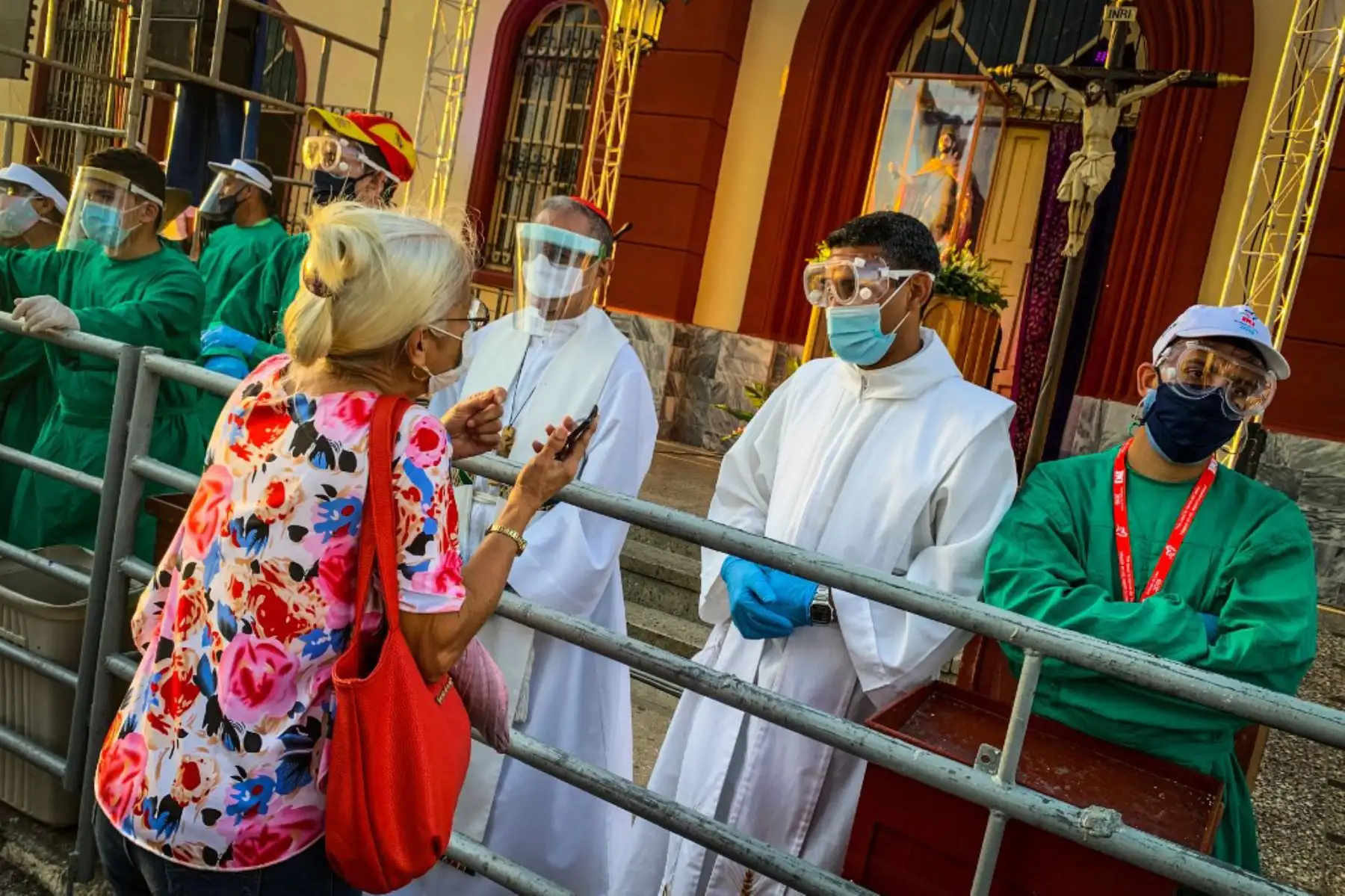 Sacerdotes con mascarillas, escudos y guantes reciben a un peregrino durante la procesión de San Lázaro en El Rincón, provincia de La Habana, Cuba. Foto: AFP
