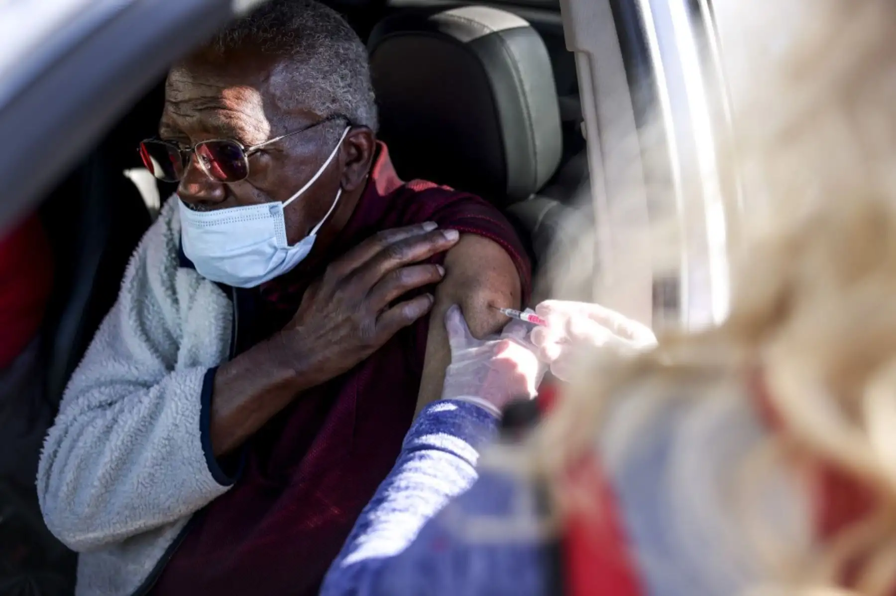 Un hombre recibe su primera dosis de la vacuna Covid-19 administrada durante vacunaciones masivas en el estadio de béisbol Coors Field, en Denver, Colorado. Foto: AFP