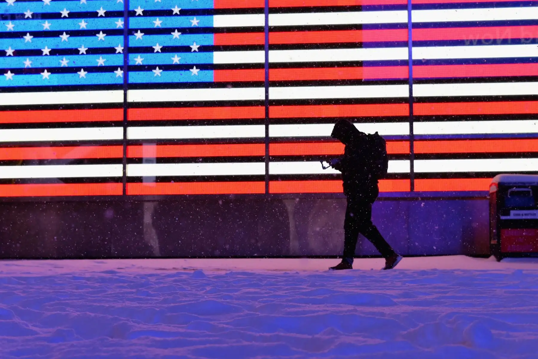 Un hombre camina frente a la bandera estadounidense tras la llegada de una gran nevada en Nueva York.

Foto:AFP