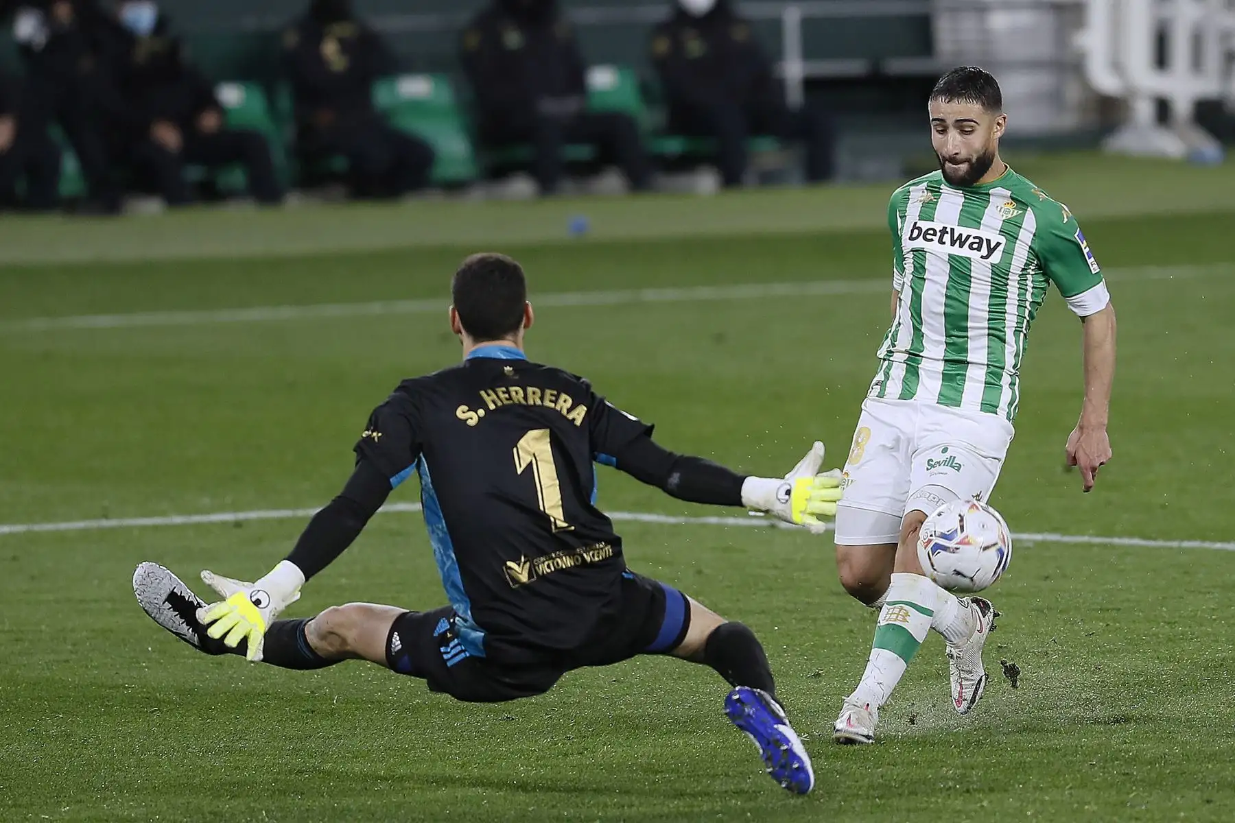 El centrocampista del Betis Nabil Fekir  trata de superar al portero Sergio Herrera, de Osasuna, durante el partido de Liga en Primera División que disputan  en el estadio Benito Villamarín, en Sevilla. 
Foto: EFE