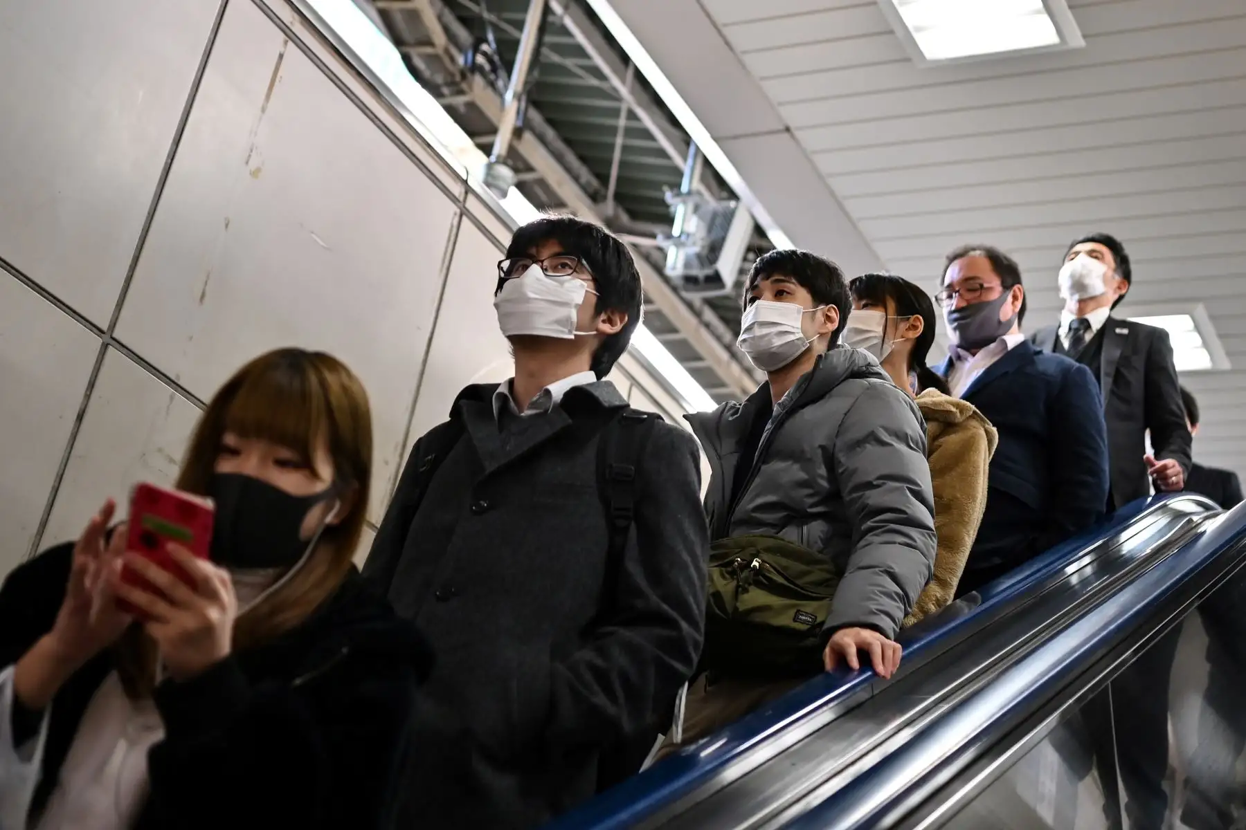 Personas usan una escalera mecánica en una estación del tren en Tokio. El gobierno de Japón aprobó extensión de un mes de su estado de emergencia por coronavirus.