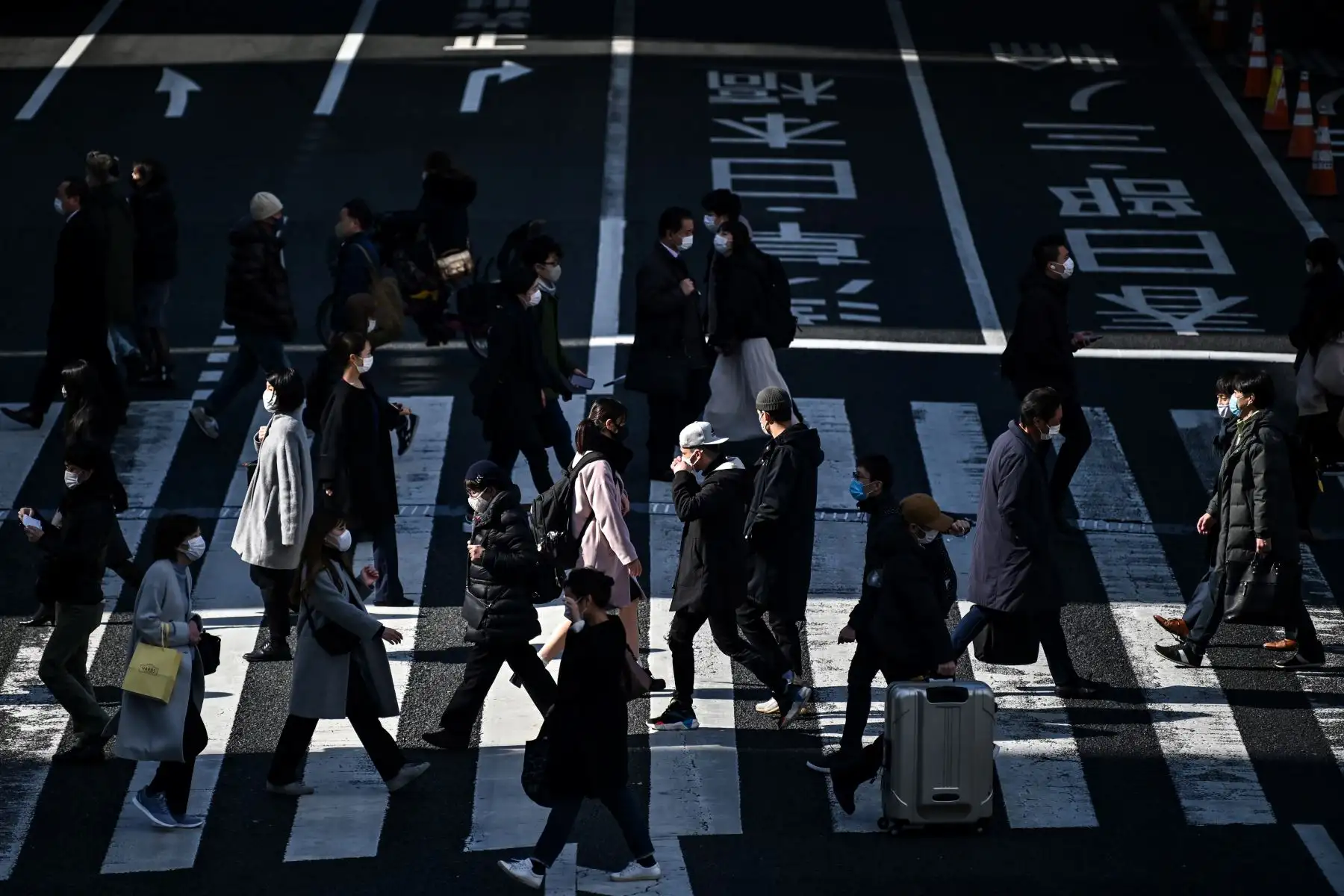 La gente cruza una calle principal en Tokio. El gobierno de Japón aprobó extensión de un mes de su estado de emergencia por coronavirus. Foto: AFP
