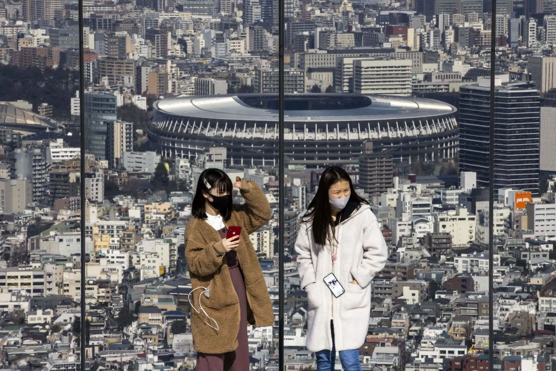 Personas con mascarillas visitan la plataforma de observación Shibuya Sky en el Estadio Nacional de Japón, la sede principal de los Juegos Olímpicos y Paralímpicos de Tokio. El gobierno de Japón aprobó extensión de un mes de su estado de emergencia por coronavirus. Foto: AFP