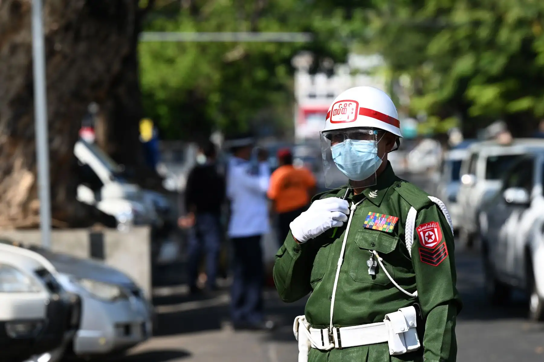 Un soldado hace guardia mientras las tropas llegan a un templo hindú en Yangon, Birmania