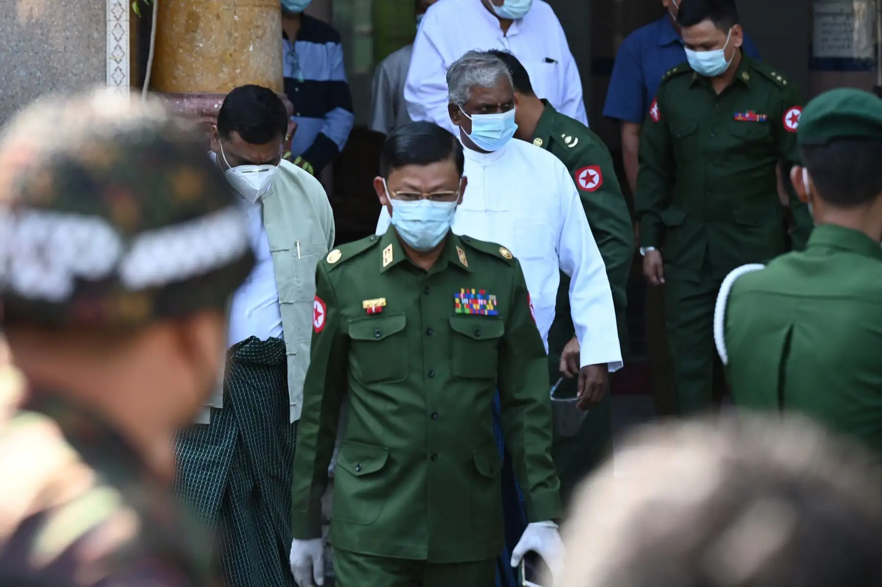 Un oficial militar (C) acompañado por soldados sale de un templo hindú en Yangon el 2 de febrero de 2021, a un día del golpe de Estado. Foto: AFP