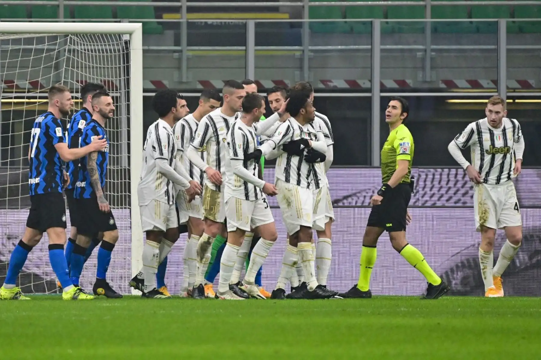 El centrocampista colombiano de la Juventus Juan Cuadrado (CR) reacciona junto al árbitro italiano Gianpaolo Calvarese después de ser empujado en el área penal durante el partido de ida de cuartos de final de la Copa de Italia entre el Inter de Milán y la Juventus de Turín el 2 de febrero de 2021 en el San Estadio Siro de Milán. Foto: AFP