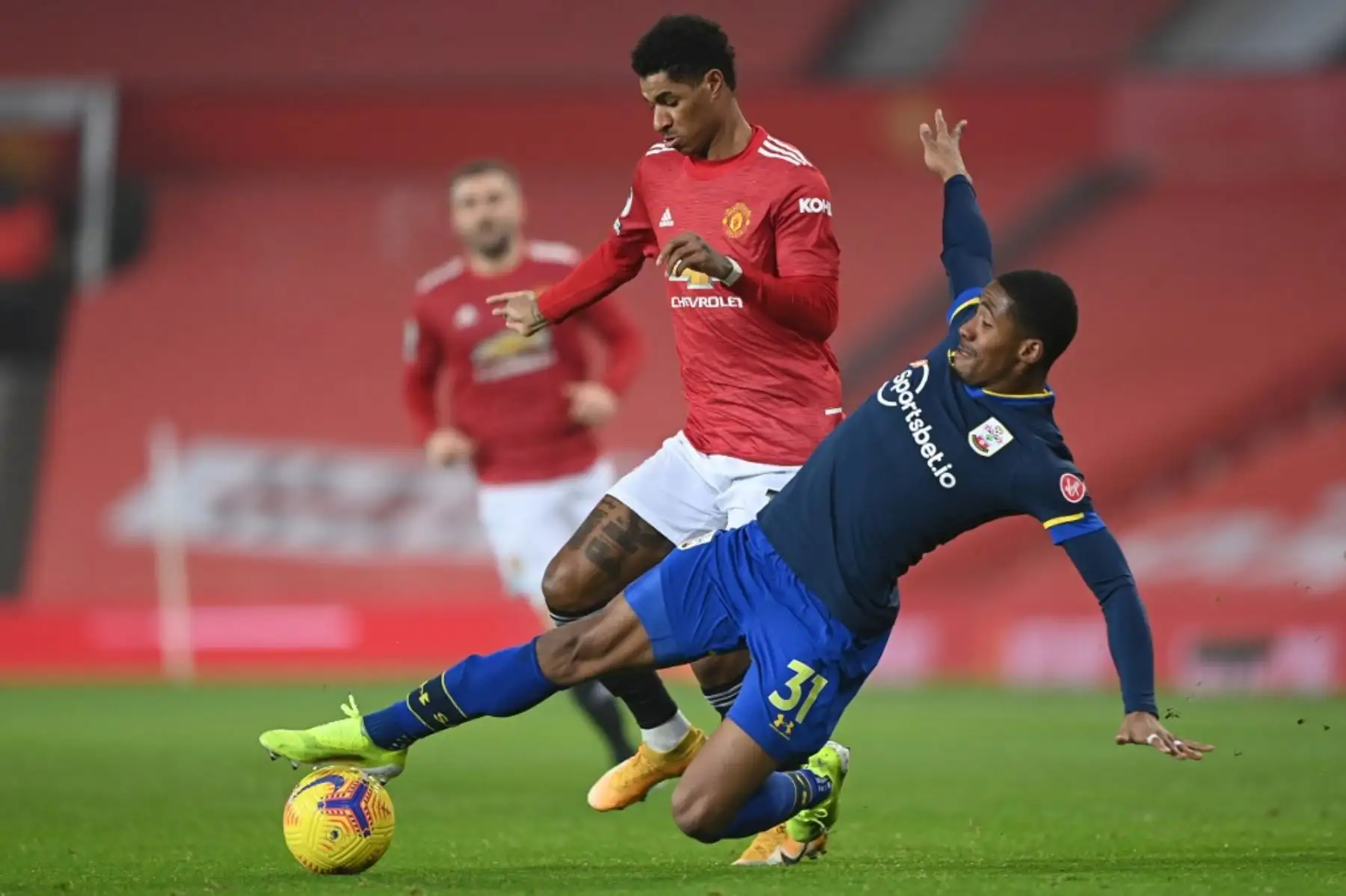 El delantero inglés del Manchester United Marcus Rashford es abordado por el defensor inglés del Southampton Kayne Ramsay durante el partido de fútbol de la Premier League inglesa entre el Manchester United y el Southampton en Old Trafford en Manchester, noroeste de Inglaterra, el 2 de febrero de 2021. Foto: AFP