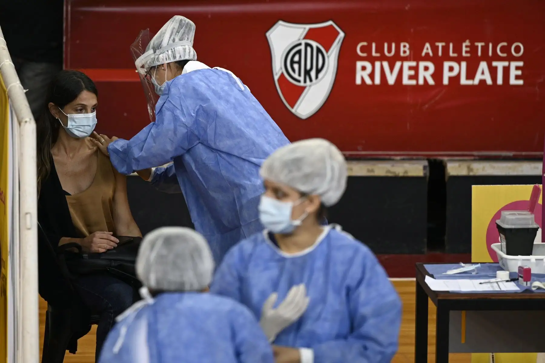 Un trabajador de la salud recibe una dosis de la vacuna Sputnik V contra covid -19, en la cancha de baloncesto del club argentino River Plate, debajo de la tribuna del estadio Monumental, en Buenos Aires.
Foto: AFP