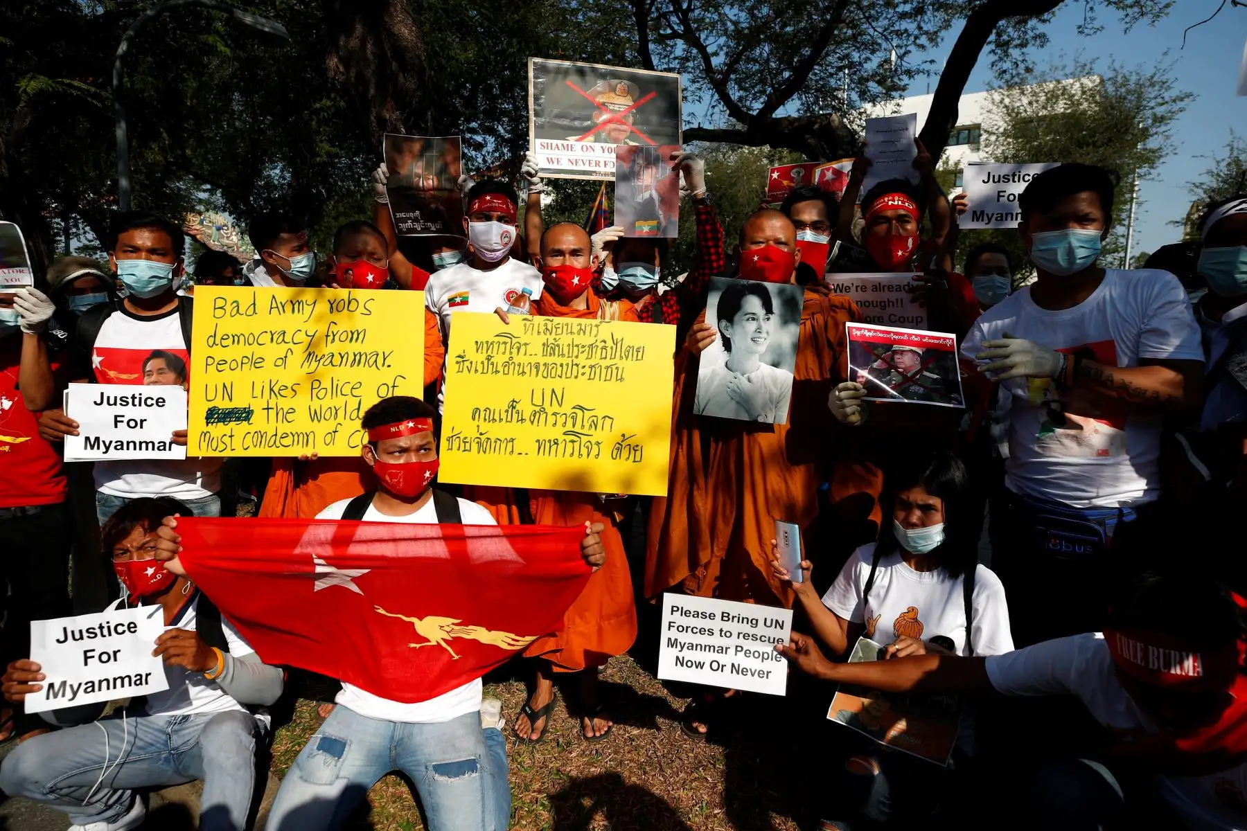 Monjes budistas junto a manifestantes birmanos con carteles y fotos del icono de la democracia birmana Aung San Suu Kyi durante una protesta contra el golpe militar birmano, frente al edificio de las Naciones Unidas en Bangkok, Tailandia. Foto: AFP