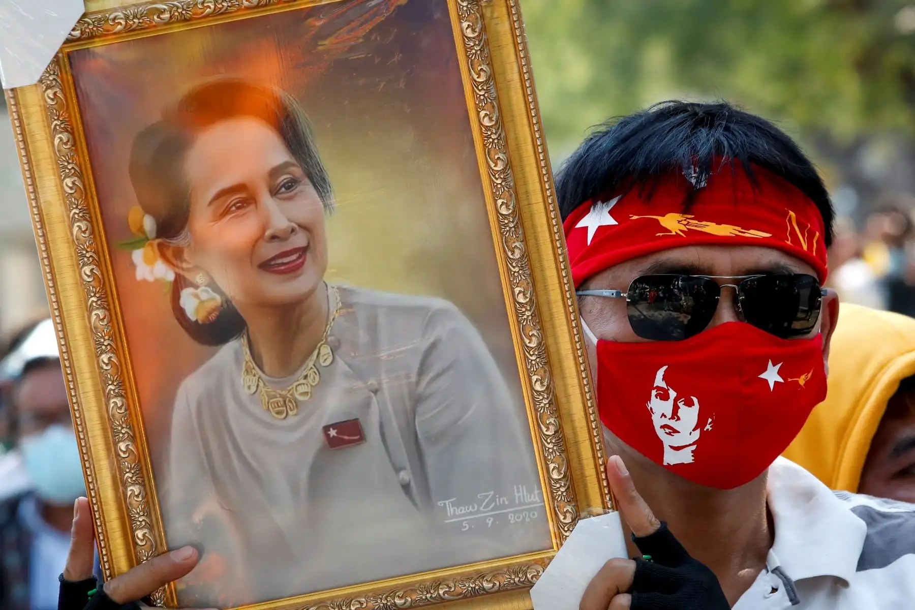 Un manifestante birmano con una máscara protectora sostiene una foto del icono de la democracia birmana Aung San Suu Kyi durante una protesta contra el golpe militar birmano, frente al edificio de las Naciones Unidas en Bangkok, Tailandia. Foto: EFE