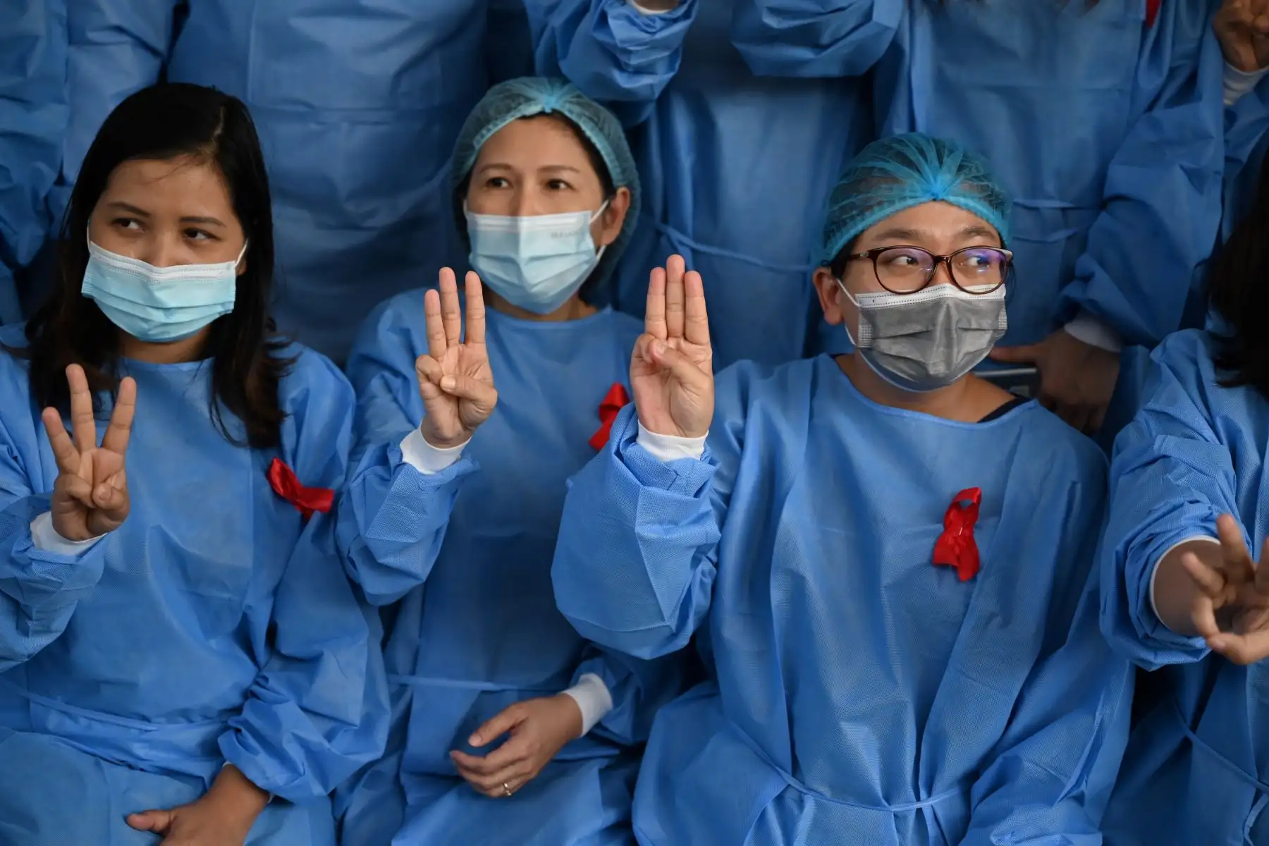 El personal médico hace un saludo de tres dedos con cintas rojas en su uniforme en el Hospital General de Yangon en Yangon mientras los llamados a la desobediencia civil se aceleran luego de un golpe militar que detuvo a la líder civil Aung San Suu Kyi. 

Foto:AFP
