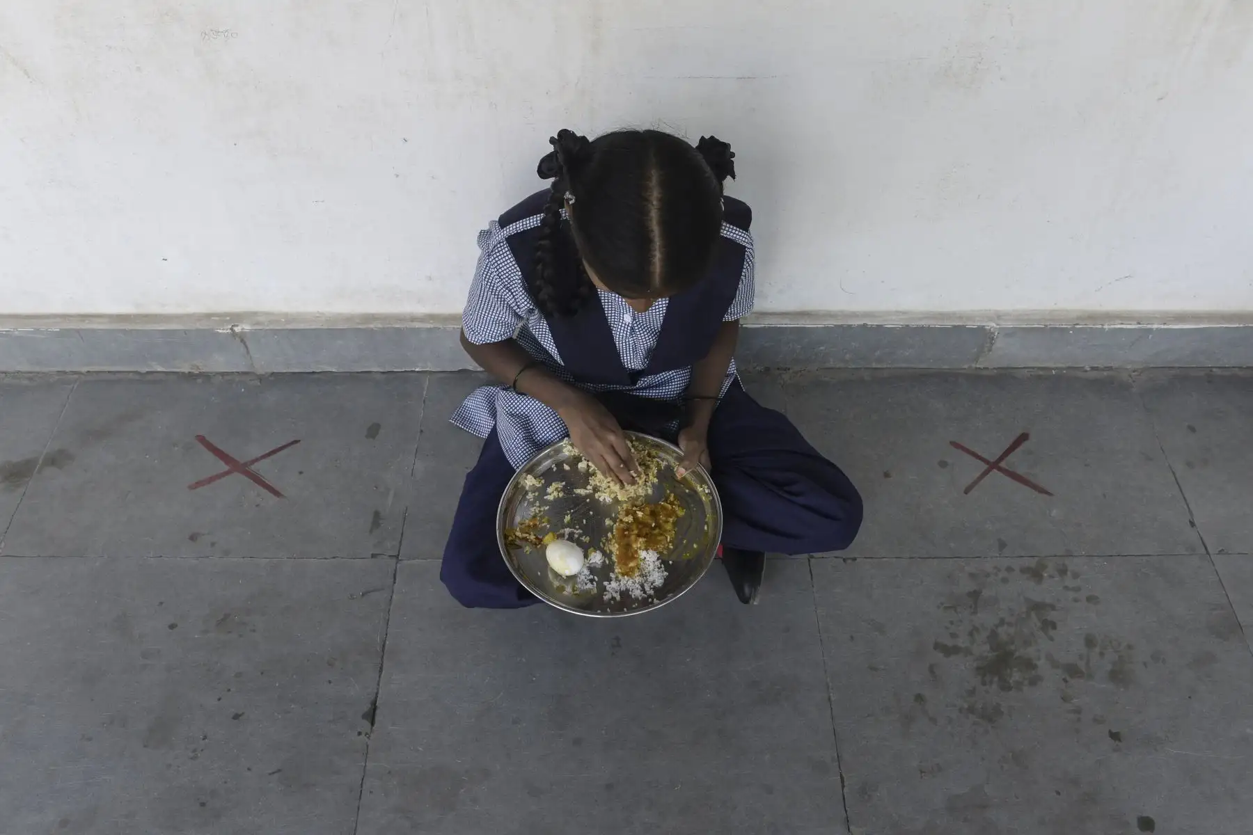 Una estudiante come su comida del mediodía servida durante el almuerzo después de que las escuelas para las clases novena y décima reabrieron casi diez meses después de la propagación del coronavirus en Hyderabad.

Foto: AFP
