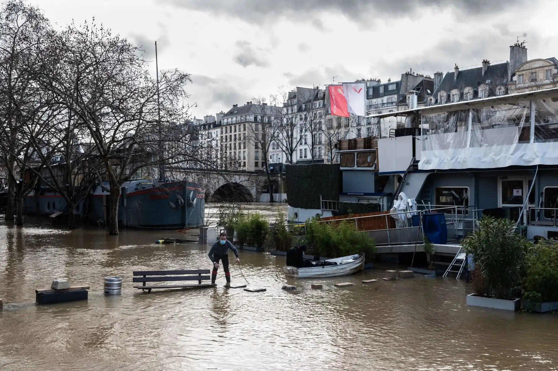 Un hombre camina cerca de las barcazas en las orillas inundadas del río Sena, en París. Foto: AFP