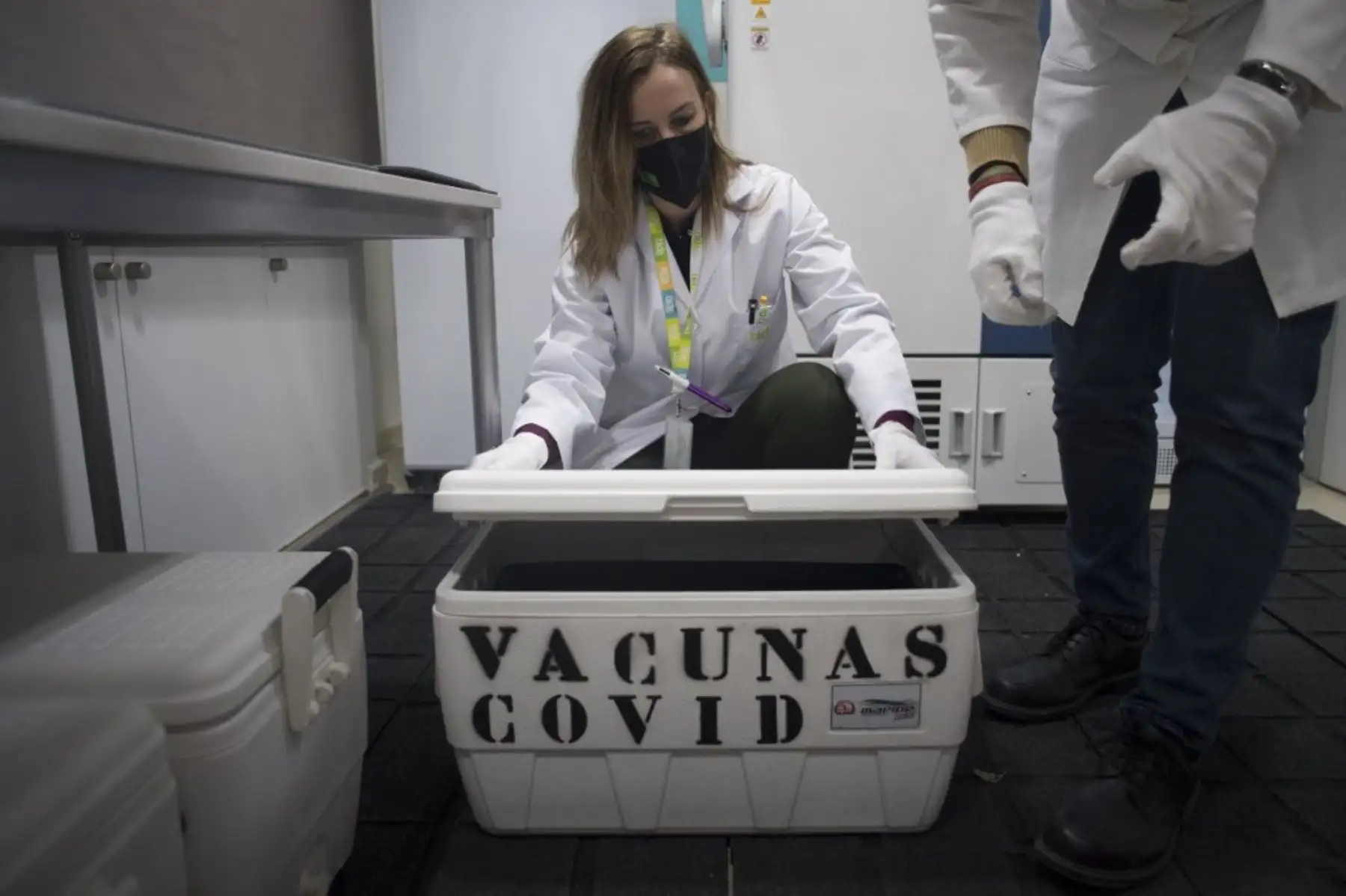 Técnico de laboratorio abre una nevera portátil con vacunas Pfizer-BioNTech Covid-19 en la cooperativa de distribución mayorista Bidafarma en Santa Fe, en las afueras de Granada. Foto: AFP