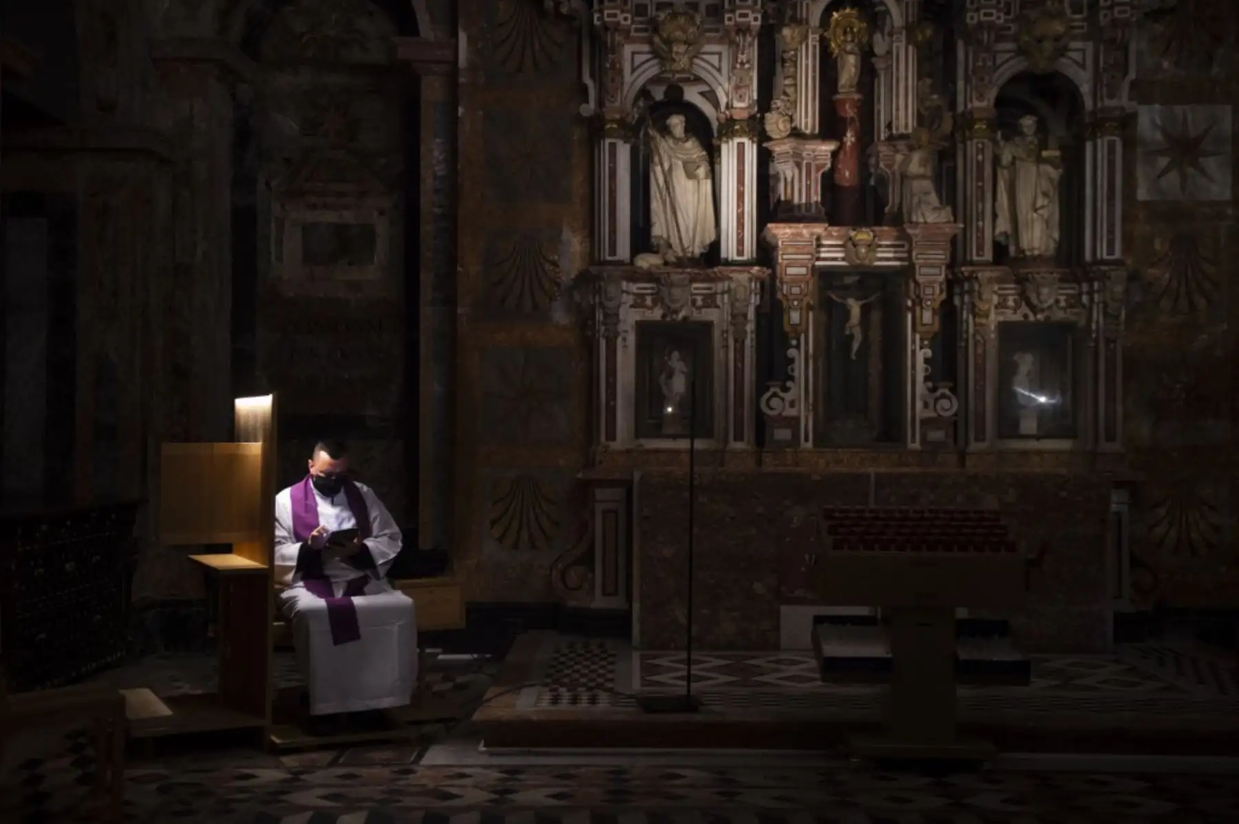 Un sacerdote espera a que los creyentes confiesen en la Catedral de Santiago de Compostela el 27 de enero de 2021 ya que permanece vacía debido a las restricciones del coronavirus y a pesar de la celebración de este año del Año Jacobeo que normalmente atrae a multitudes de peregrinos al pueblo. Foto: AFP
