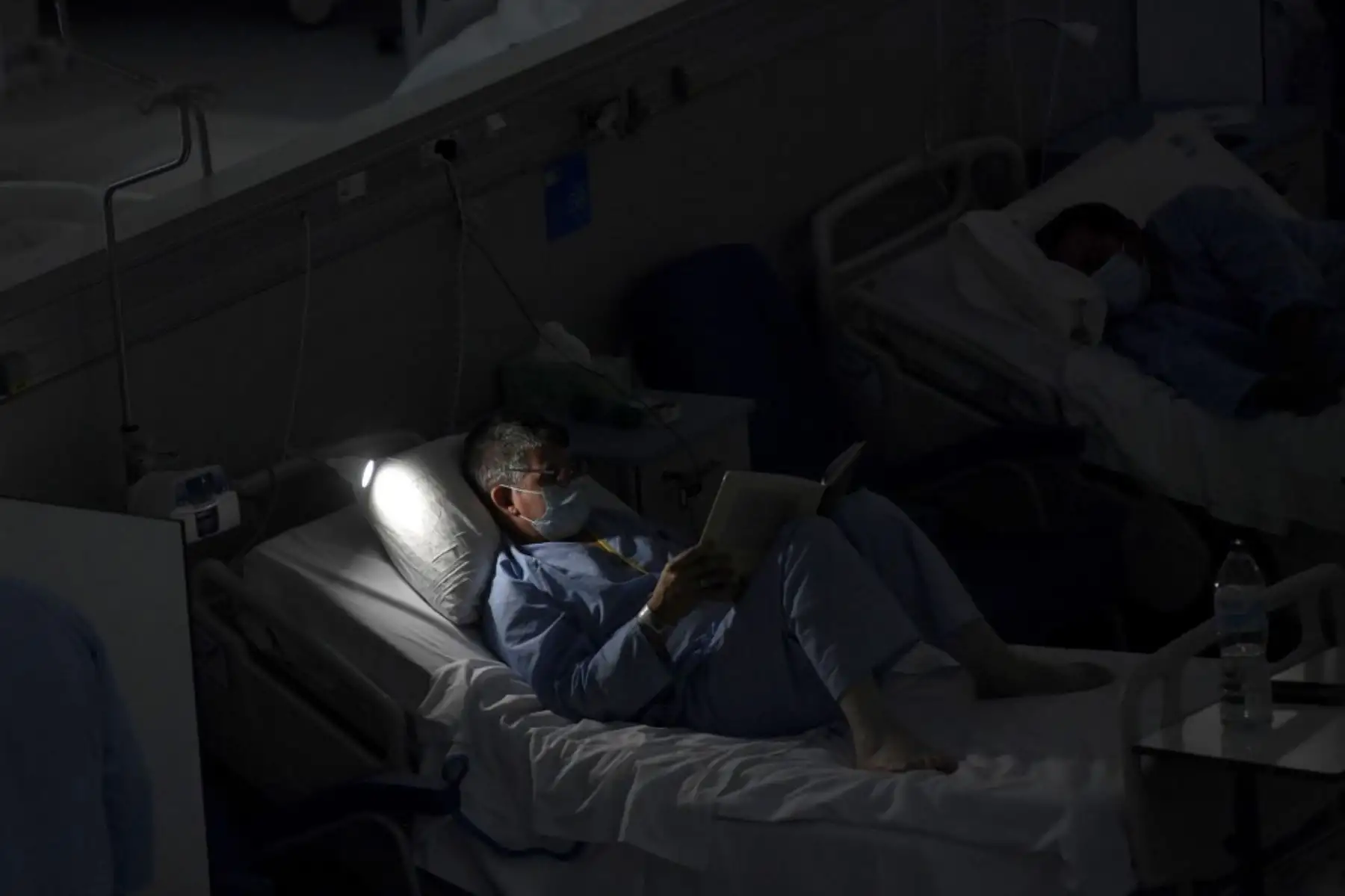 Un paciente lee en el área cobid-19 del nuevo hospital de urgencias Enfermera Isabel Zendal, en Madrid. Foto: AFP