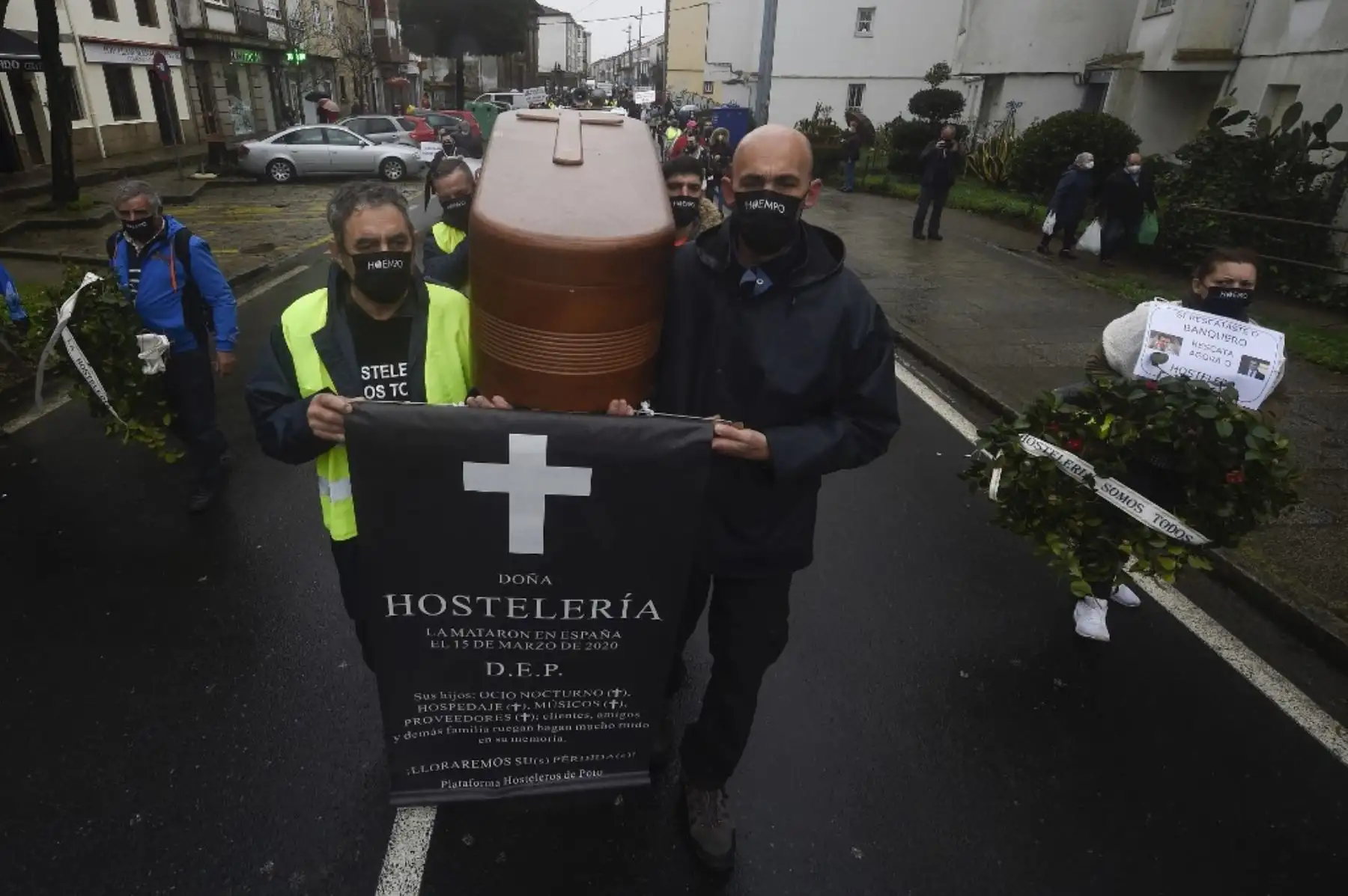 Manifestantes portan un féretro simulado durante una protesta de la industria hotelera contra las nuevas restricciones por coronavirus por parte de la Xunta de Galicia en Santiago de Compostela, noroeste de España. Foto: AFP