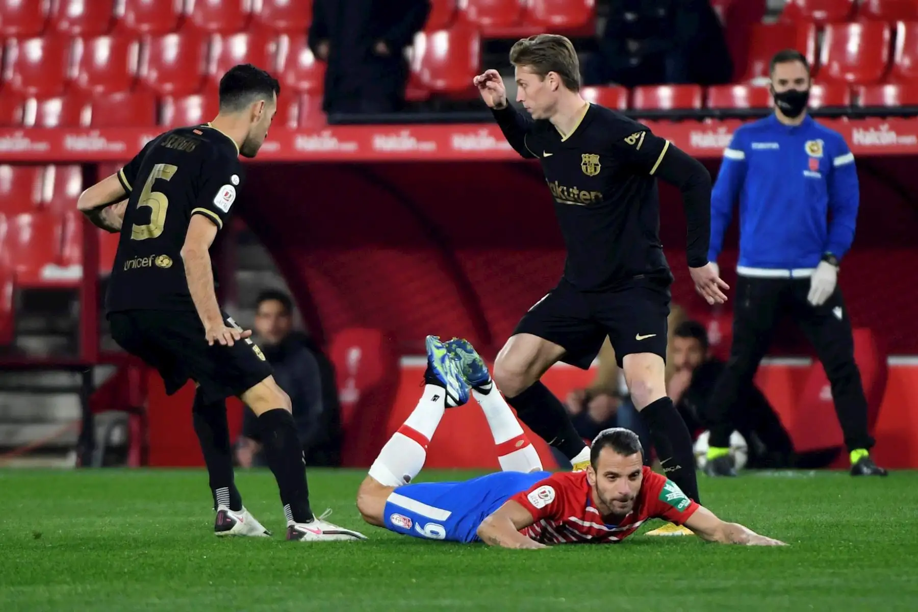 El delantero del Granada, Roberto Soldado (c), disputa un balón con los centrocampistas del FC Barcelona, el español Sergio Busquets (i) y el holandés Frenkie de Jong (d), durante el encuentro de cuartos de final de la Copa del Rey celebrado este miércoles en el estadio Nuevos Los Cármenes, en Granada. 

Foto: EFE