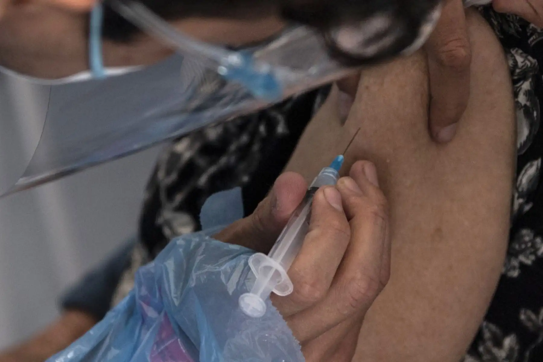 Un trabajador de la salud administra una dosis de la vacuna Sinovac CoronaVac de China a una persona en un centro de vacunación montado en el Estadio Bicentenario en Santiago, mientras comienza una campaña masiva de vacunación contra el nuevo coronavirus, covid-19, en Chile, el 3 de febrero de 2021. Foto: AFP