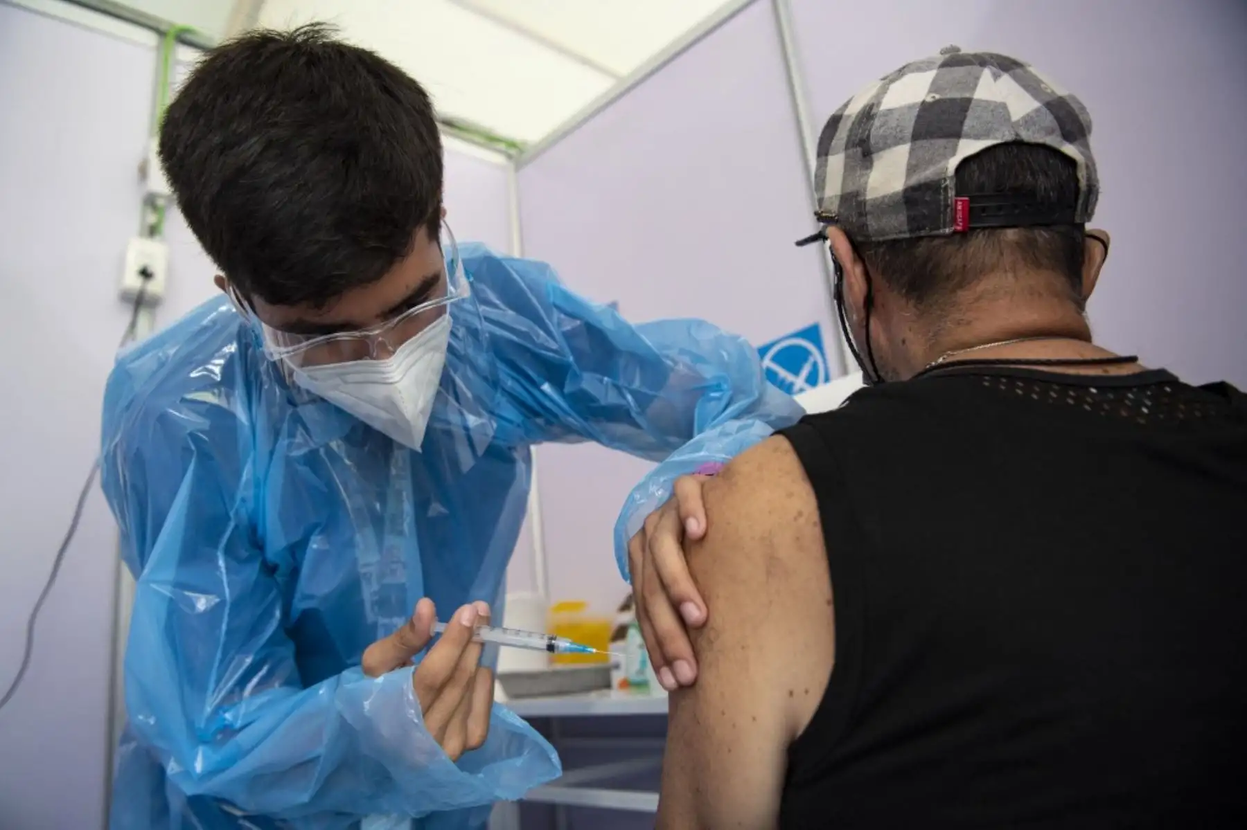 Un trabajador de la salud administra una dosis de la vacuna Sinovac CoronaVac de China a una persona en un centro de vacunación montado en el Estadio Bicentenario en Santiago, mientras comienza una campaña masiva de vacunación contra el nuevo coronavirus, covid-19, en Chile, el 3 de febrero de 2021. Foto: AFP