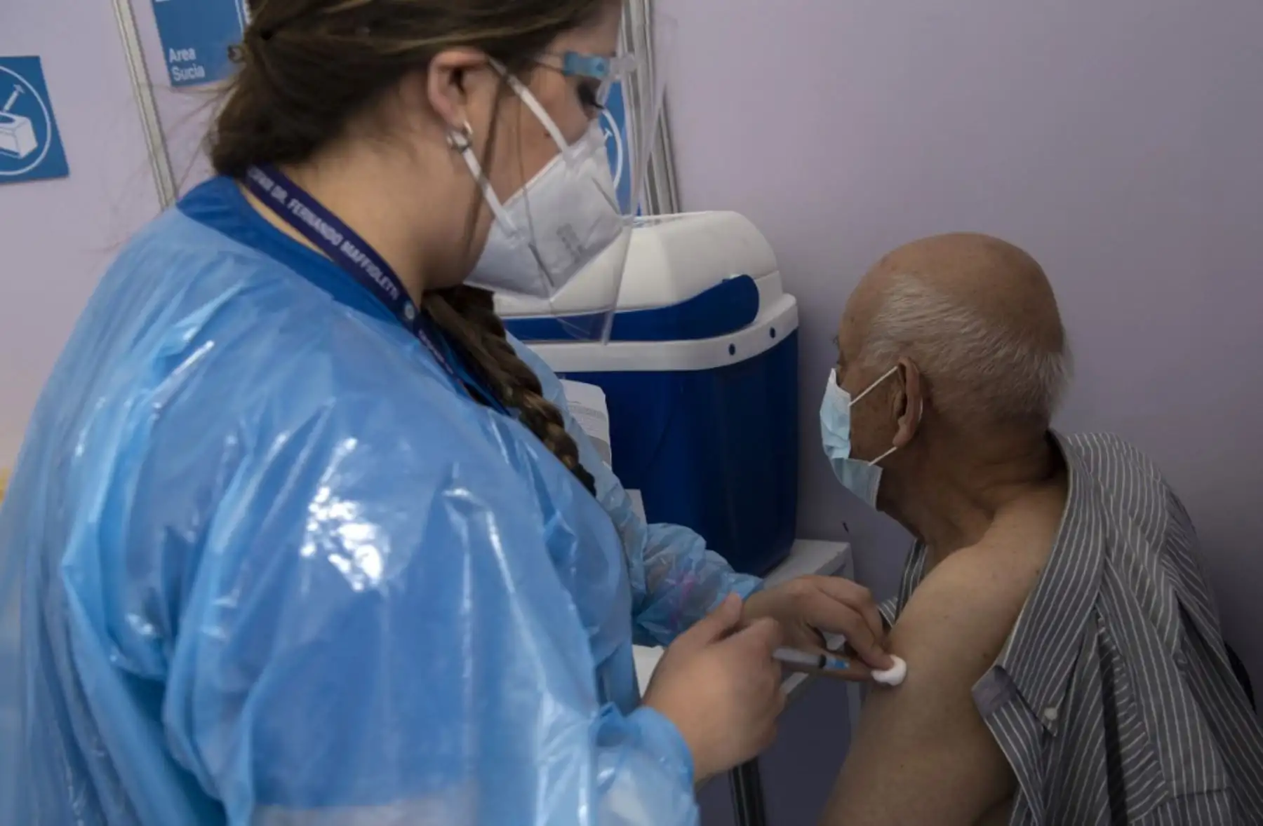 Un trabajador de la salud administra una dosis de la vacuna Sinovac CoronaVac de China a una persona en un centro de vacunación montado en el Estadio Bicentenario en Santiago, mientras comienza una campaña masiva de vacunación contra el nuevo coronavirus, covid-19, en Chile, el 3 de febrero de 2021. Foto: AFP