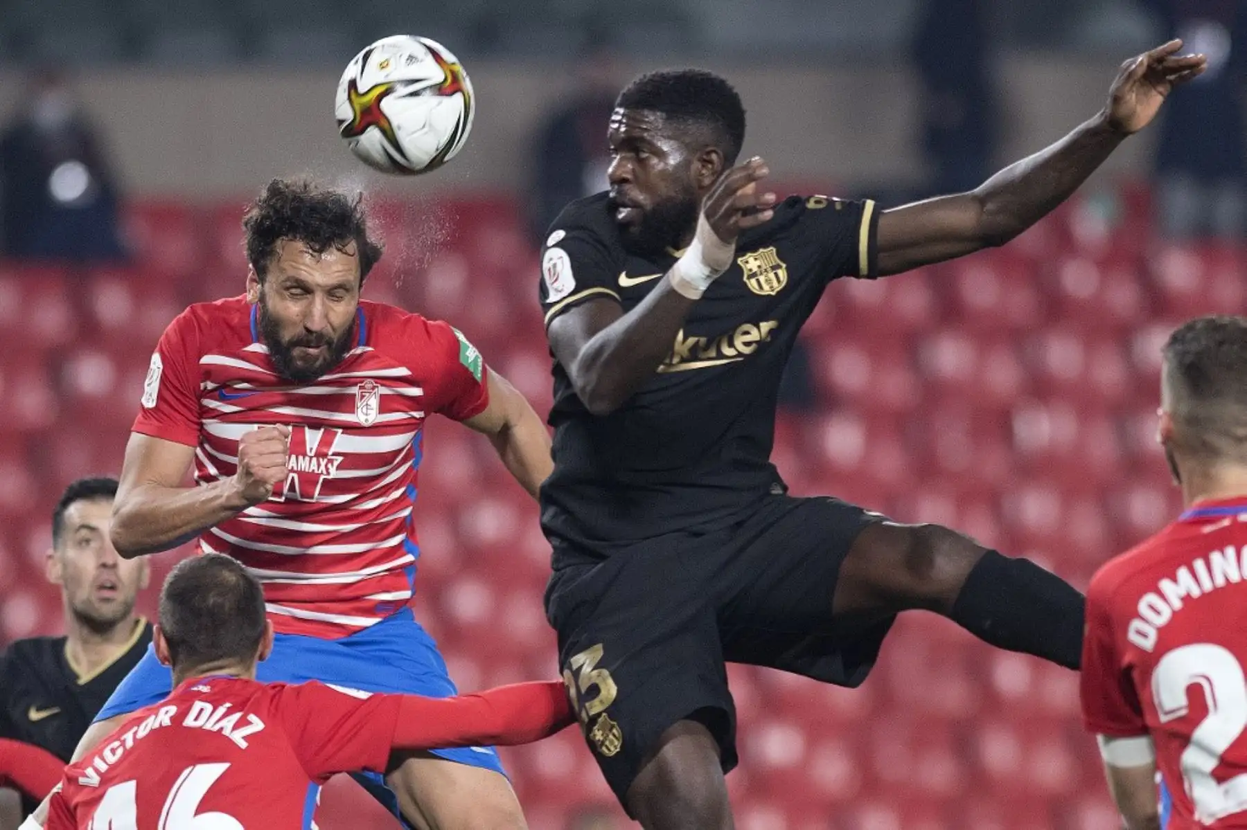 El defensor español del Granada, German Sánchez, cabecea el balón con el defensor francés del Barcelona Samuel Umtiti durante los cuartos de final de la Copa del Rey de España entre el Granada FC y el FC Barcelona en el estadio Nuevo Los Cármenes de Granada el 3 de febrero de 2021. Foto: AFP