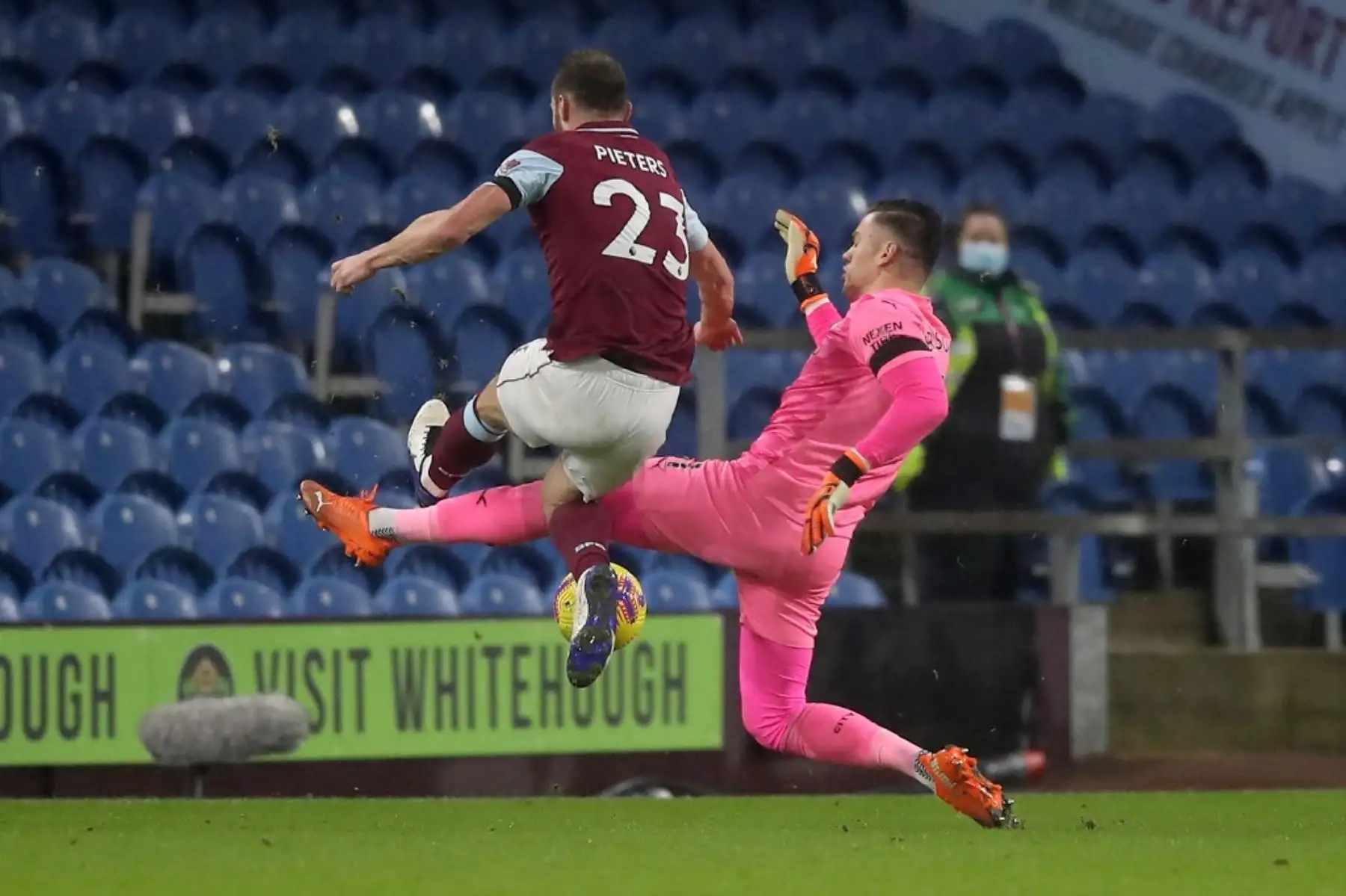 El portero brasileño del Manchester City Ederson comete una falta al defensor holandés del Burnley, Erik Pieters, durante el partido de fútbol de la Premier League inglesa entre el Burnley y el Manchester City en Turf Moor en Burnley, noroeste de Inglaterra, el 3 de febrero de 2021. Foto: AFP