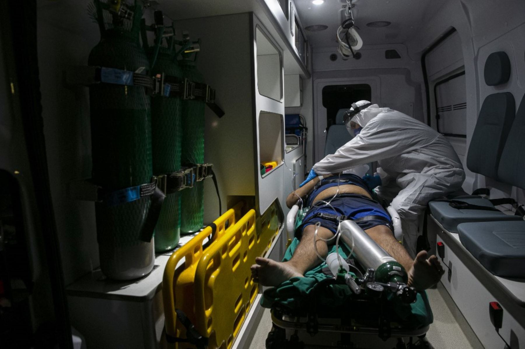 Un trabajador de la salud revisa la condición médica de un paciente con covid-19 que llegó en ambulancia desde la ciudad de Belterra en Santarem, Estado de Pará, Brasil, para ser trasladado en un avión transformado en una unidad de UCI a Itaituba, en Santarem International Aeropuerto. Foto: AFP