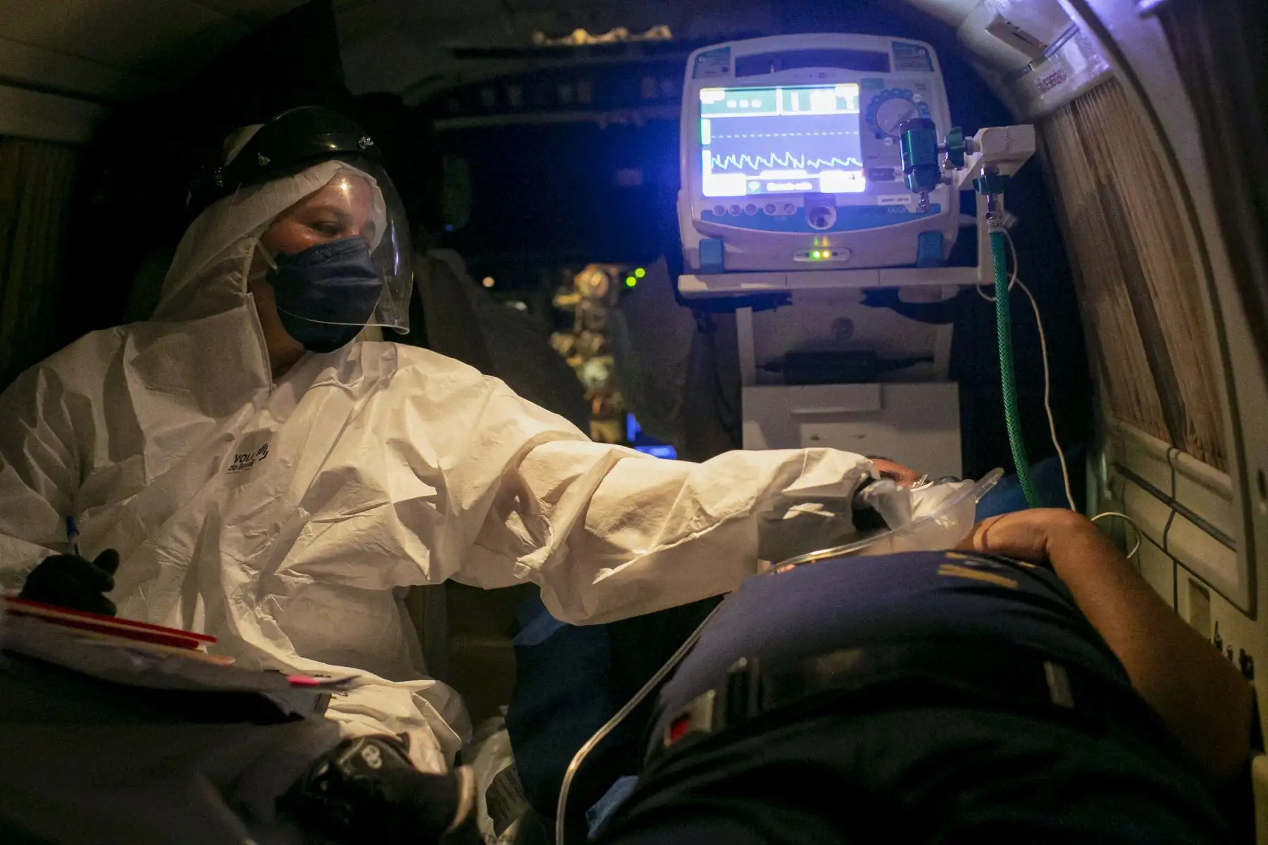 Un trabajador de la salud revisa el estado de salud de un paciente con COVID-19 de la ciudad de Belterra, en un avión transformado en una unidad de UCI, durante el vuelo de Santarem a Itaituba, Estado de Pará, Brasil. Foto: AFP