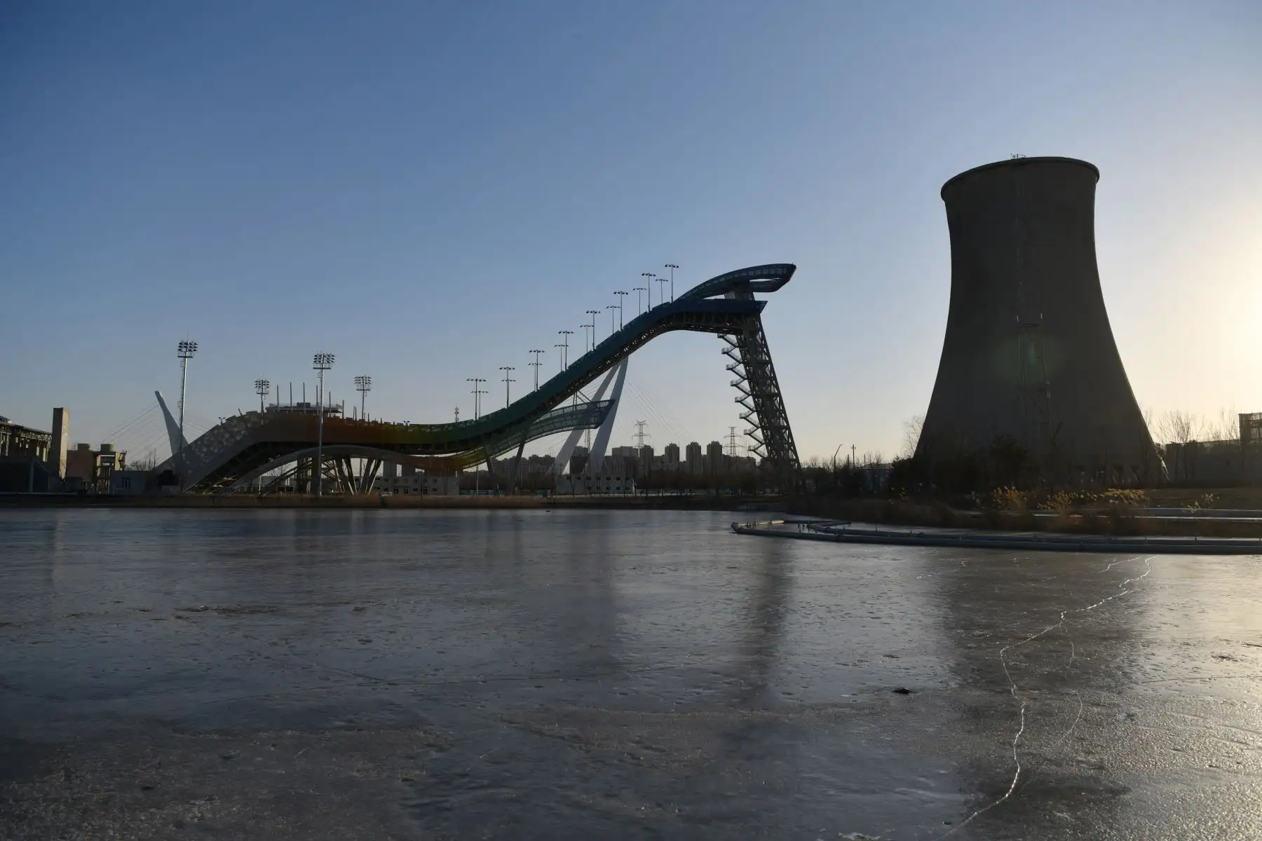 La sede de Shougang Big Air, que albergará las grandes competiciones de esquí estilo libre y snowboard en los Juegos Olímpicos de Invierno de 2022, se ve junto a una torre de refrigeración en los terrenos de una antigua fábrica de acero en Beijing. Foto: AFP