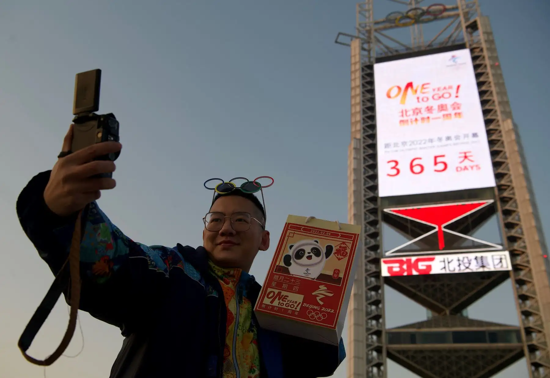 Un hombre se toma una selfie frente a una pantalla que muestra los días restantes hasta los Juegos Olímpicos de Invierno de 2022 cerca del estadio Birdís Nest, sede de las ceremonias de apertura y clausura, en Beijing. Foto: AFP