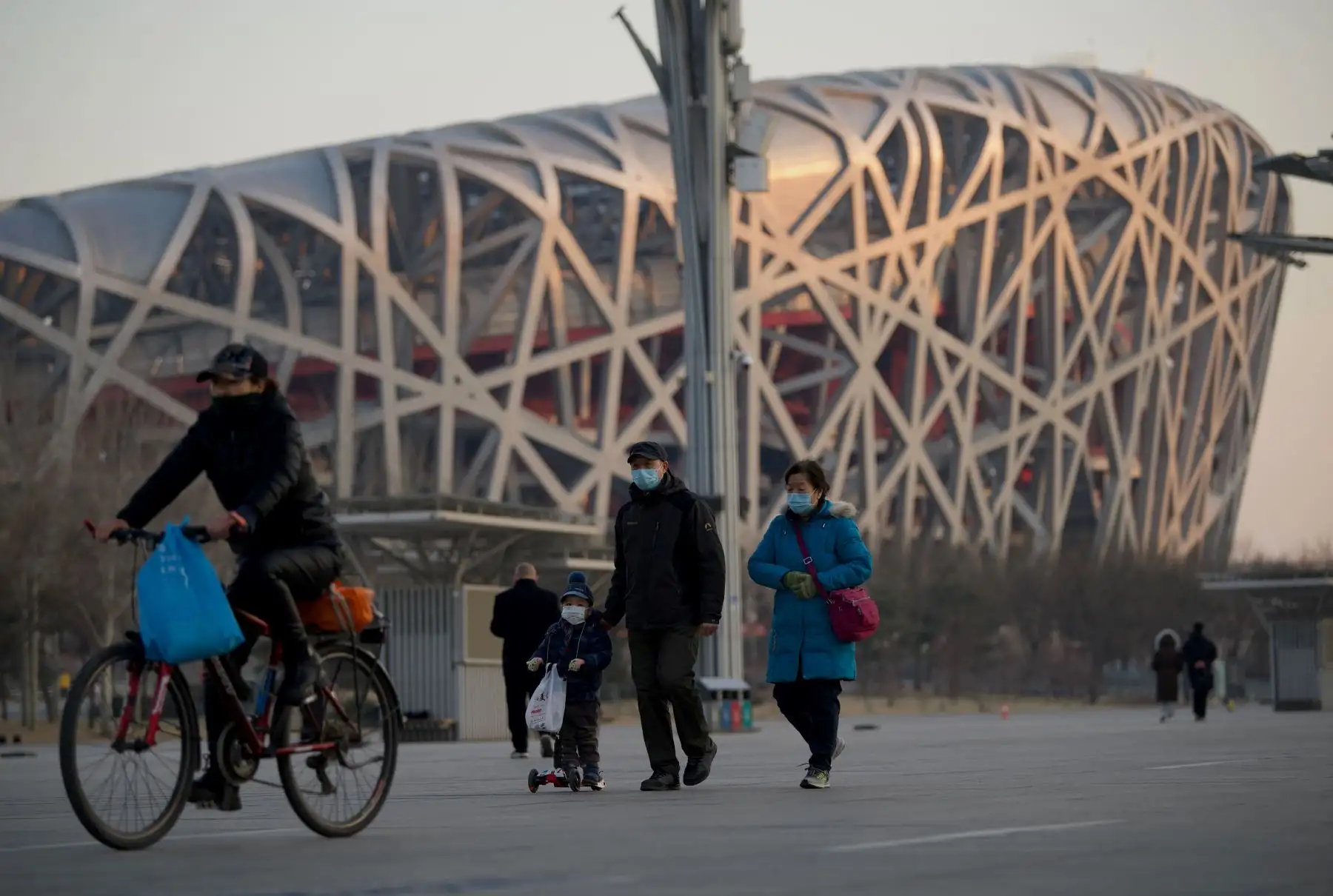 La gente pasa por el estadio Birdís Nest, sede de las ceremonias de apertura y clausura de los Juegos Olímpicos de Invierno de 2022, en Beijing. Foto: AFP