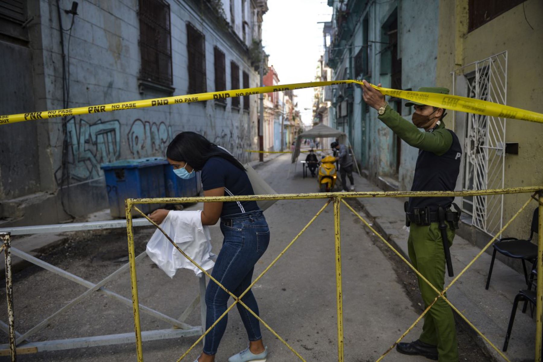 Un trabajador de salud abandona un área acordonada por la policía por presentar casos de covid-19, en La Habana. Foto: AFP