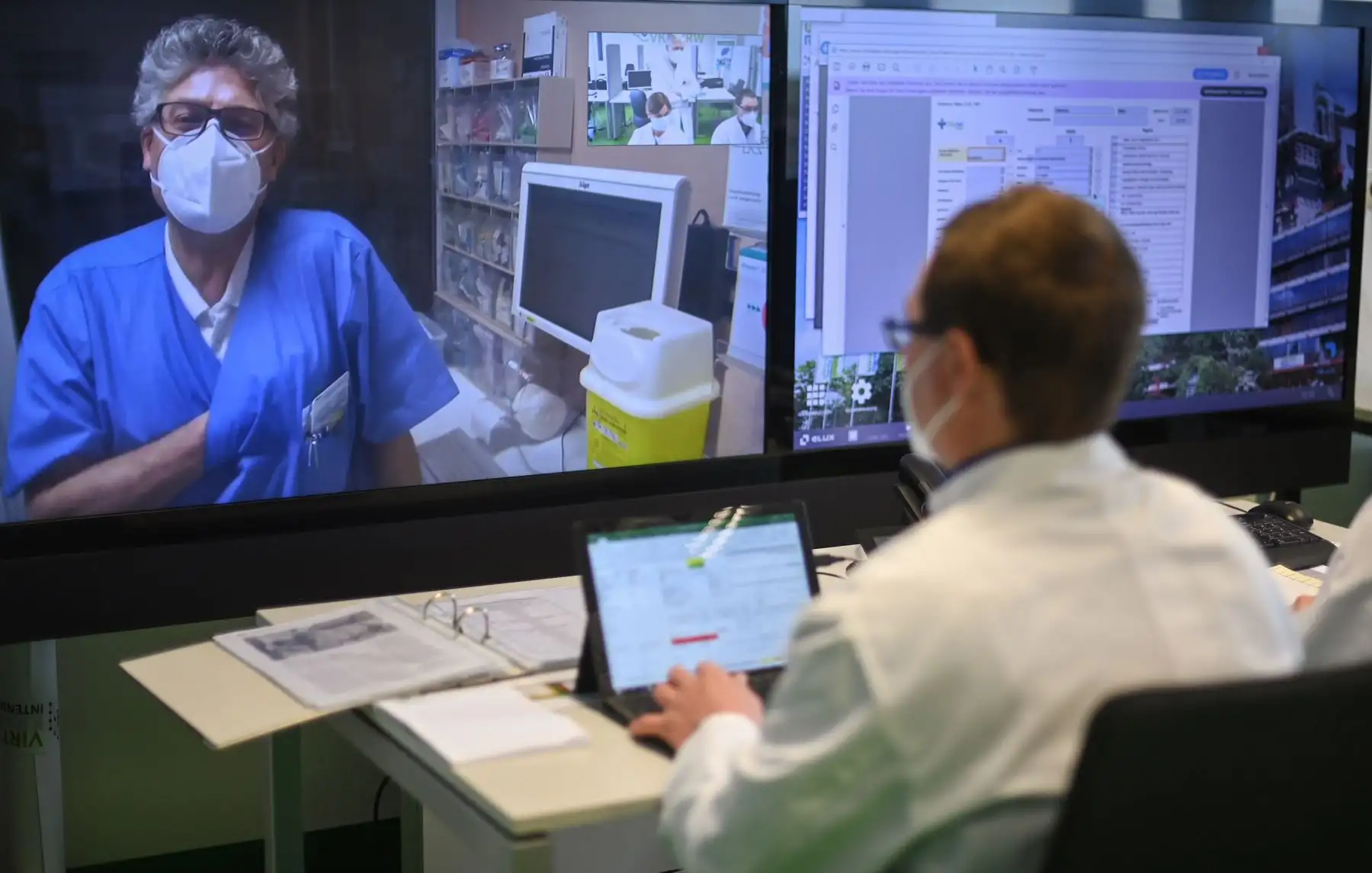 El consultor principal y médico a cargo del Hospital Bethlehem en Stolberg Andreas Bootsveld en la pantalla habla con los médicos del hospital universitario en Aquisgrán, mientras usa la telemedicina para el tratamiento de pacientes con Covid-19. Foto: AFP