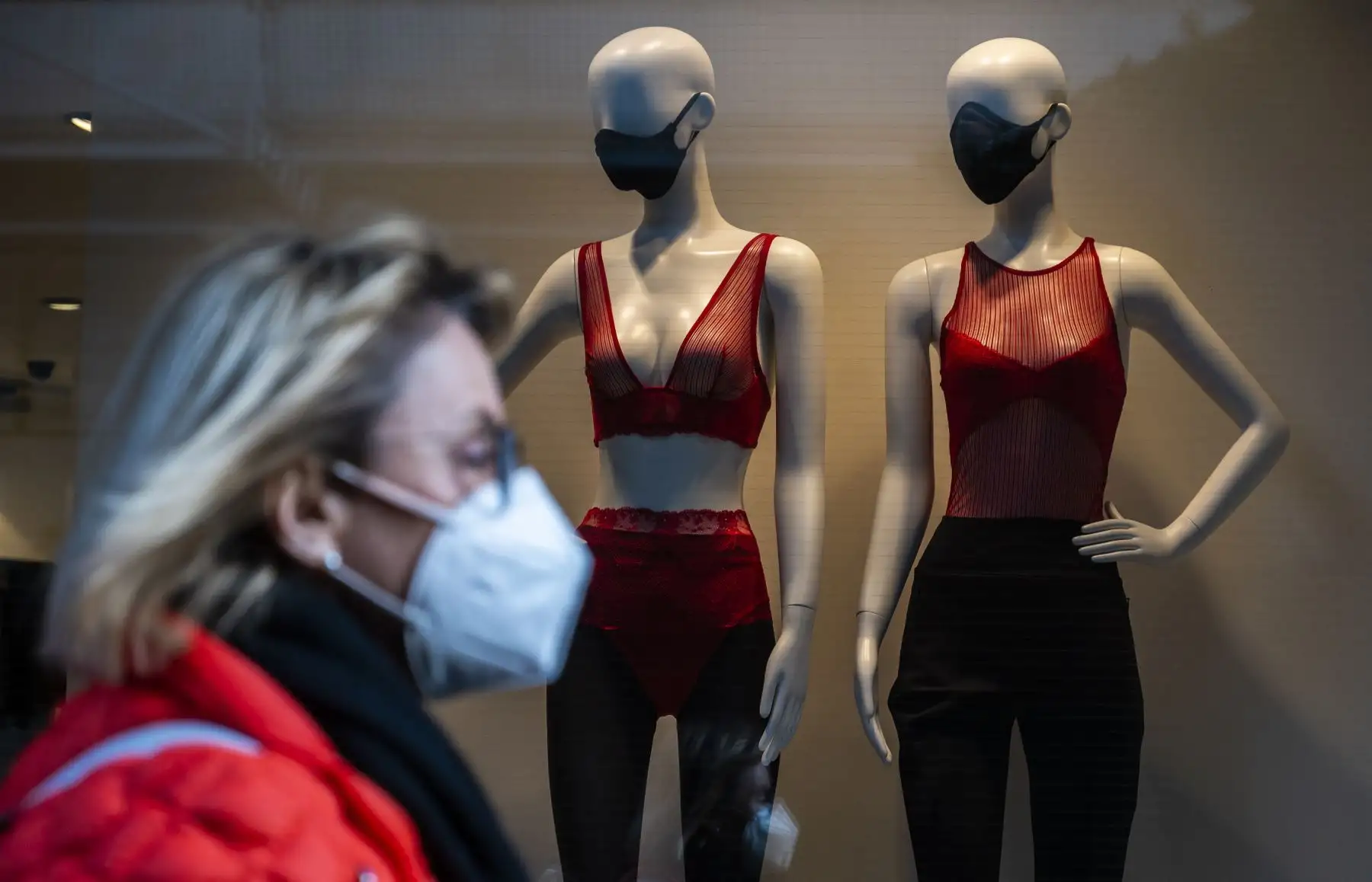 Maniquíes con mascarillas se exhiben en el escaparate de una tienda de ropa cuando un peatón pasa por la Friedrichstrasse de Berlín. La economía alemana probablemente crecerá un 3 por ciento en 2021, a pesar del impacto del COVID-19 lo dijo el Ministro de Economía Peter Altmaier. Foto: AFP