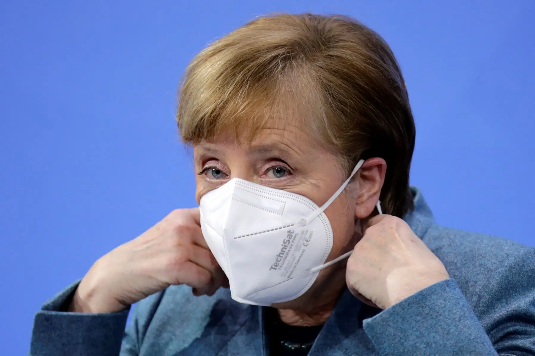 La canciller alemana Angela Merkel se quita la mascarilla antes de una conferencia de prensa después de reunirse con los productores de vacunas y los primeros ministros de estado de Alemania. Foto:AFP