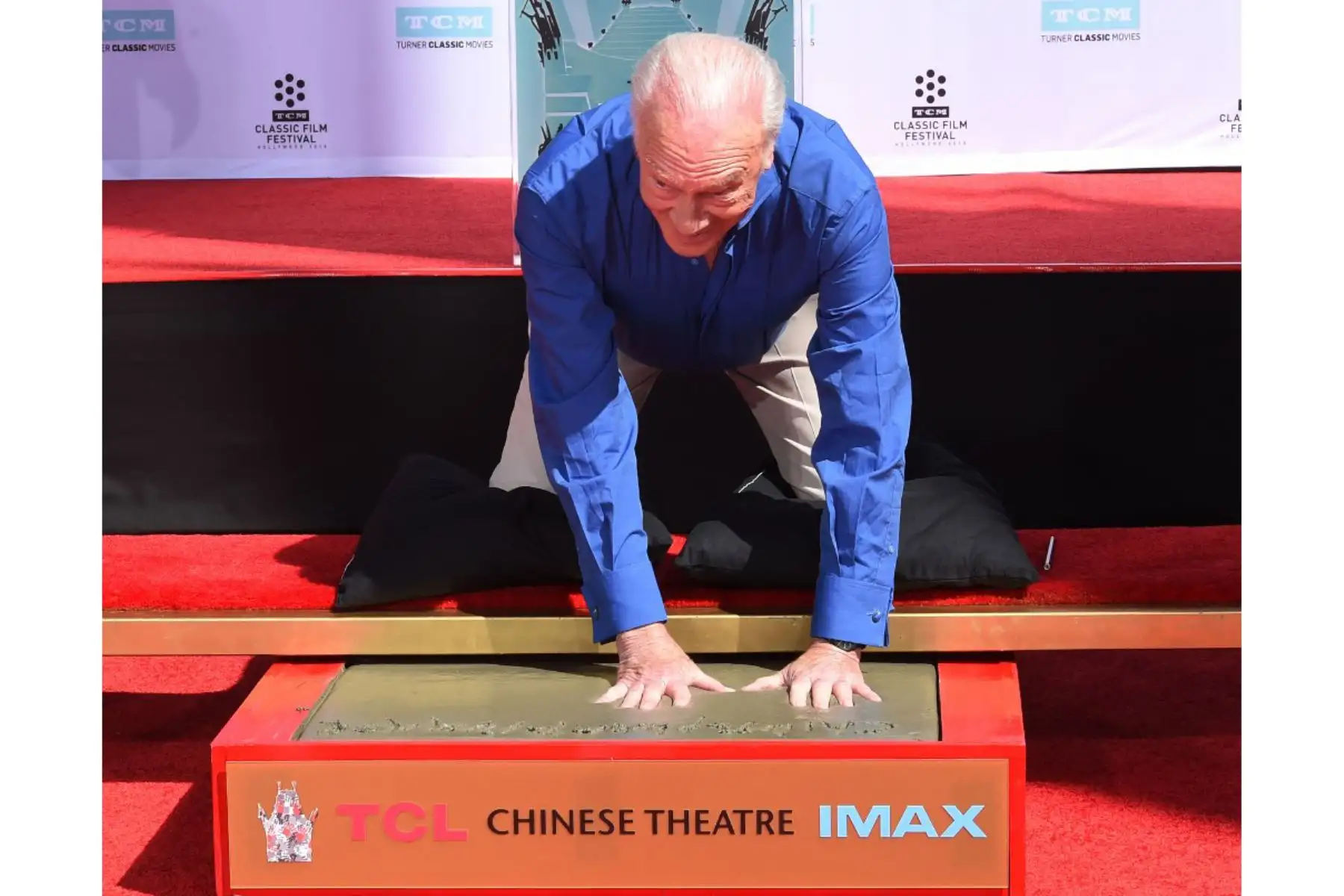 El actor Christopher Plummer mete sus manos en el cemento mientras es honrado con una Ceremonia de Manos y Huellas fuera del Teatro Chino TCL en Hollywood, California el 27 de marzo de 2015. Foto: AFP