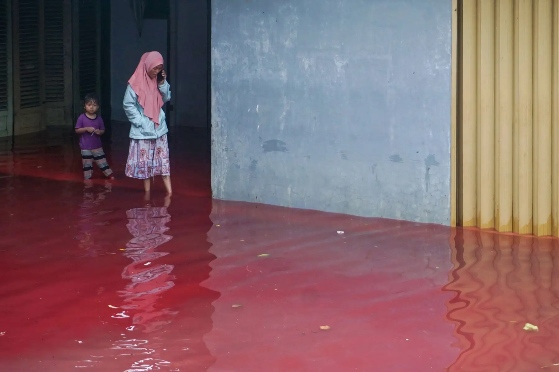 Los residentes atraviesan las inundaciones teñidas de rojo de los desechos de una fábrica de batik, un producto textil tradicional, en Pekalongan, Java central.
Foto: AFP