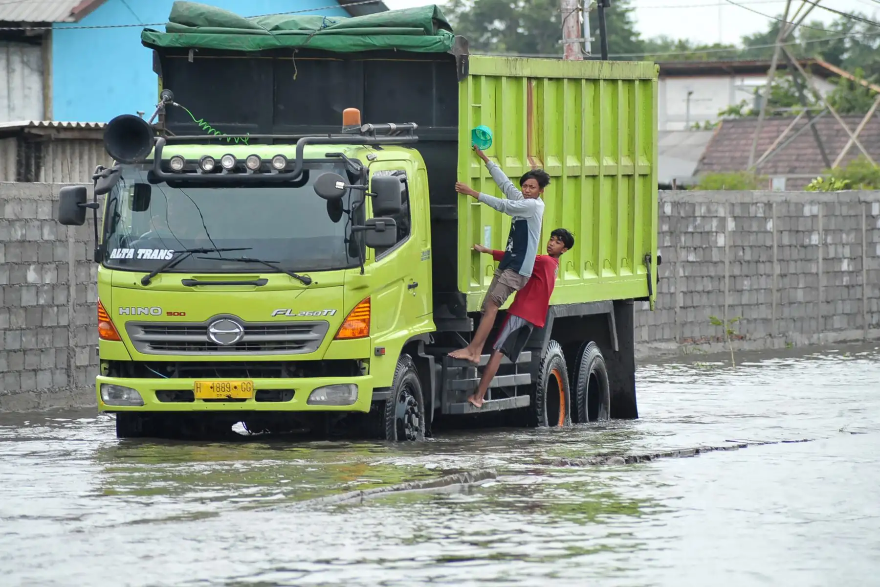 Dos niños viajan en un camión a través de una calle inundada en Semarang.
Foto: AFP