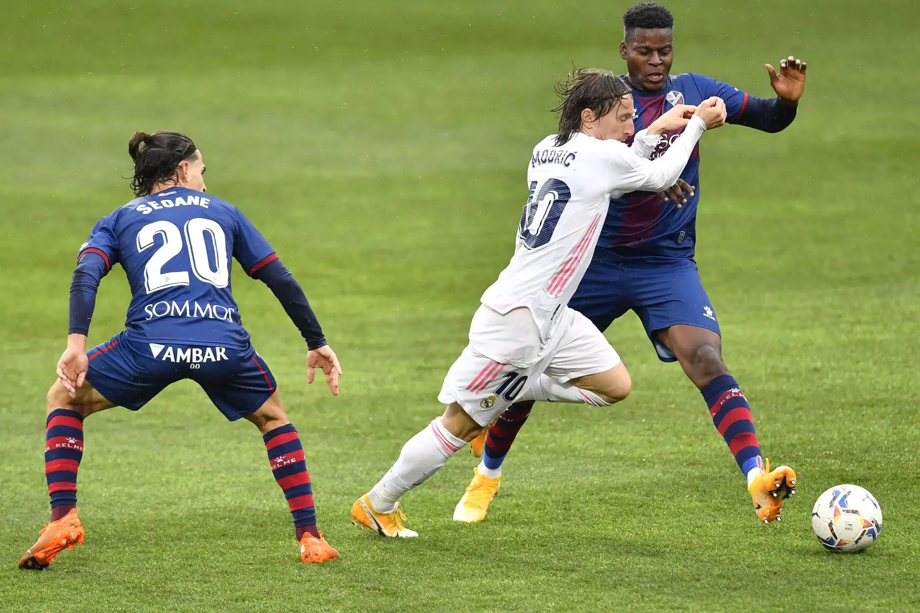 El centrocampista español del Huesca Jaime Seoane y el centrocampista marfileño del Huesca Idrissa Doumbia desafían al centrocampista croata del Real Madrid Luka Modric durante el partido de fútbol de la liga española entre la SD Huesca y el Real Madrid. 
Foto: AFP