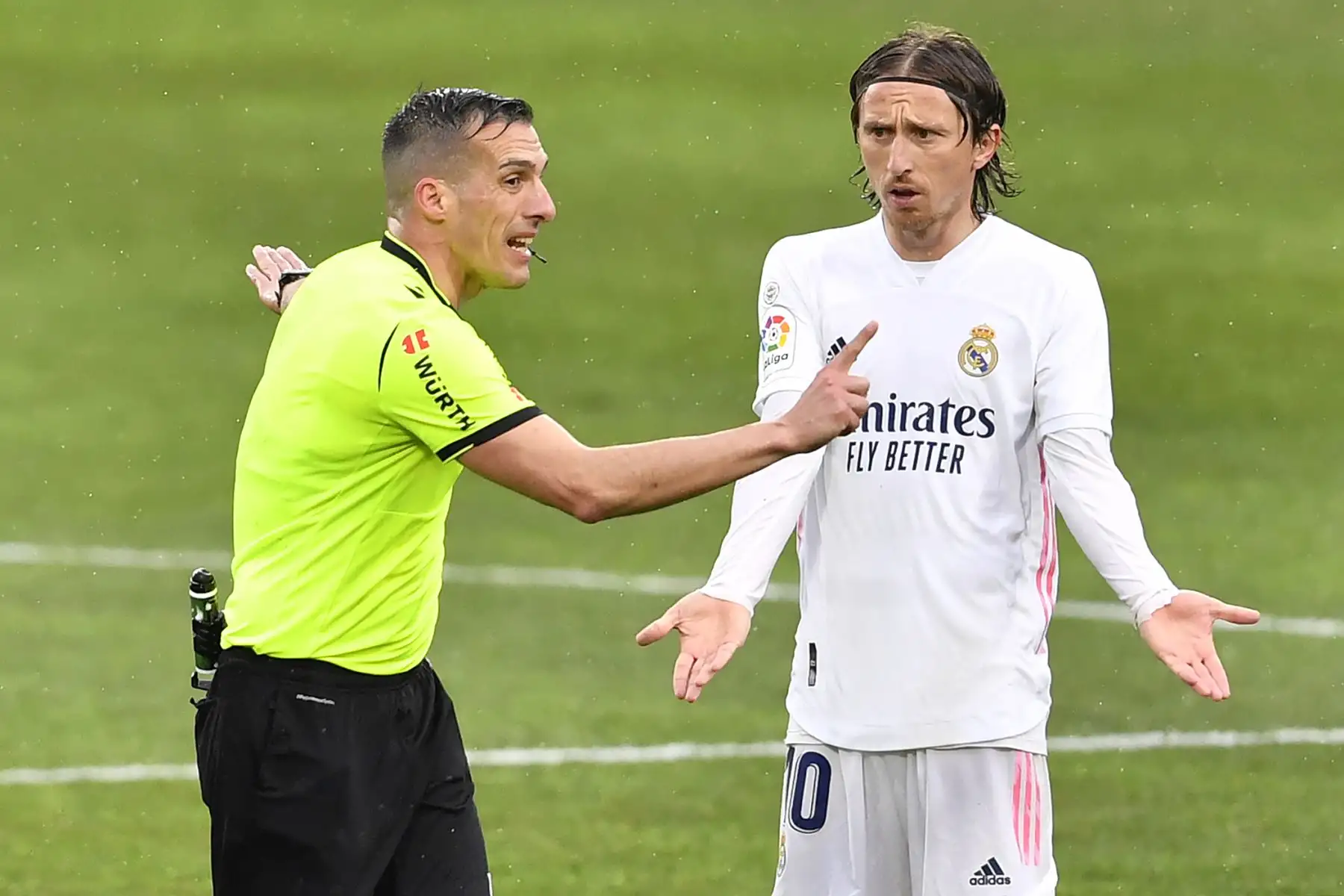 El árbitro español Xavier Estrada Fernández habla con el centrocampista croata del Real Madrid Luka Modric durante el partido de fútbol de la liga española entre la SD Huesca y el Real Madrid. 
Foto: AFP