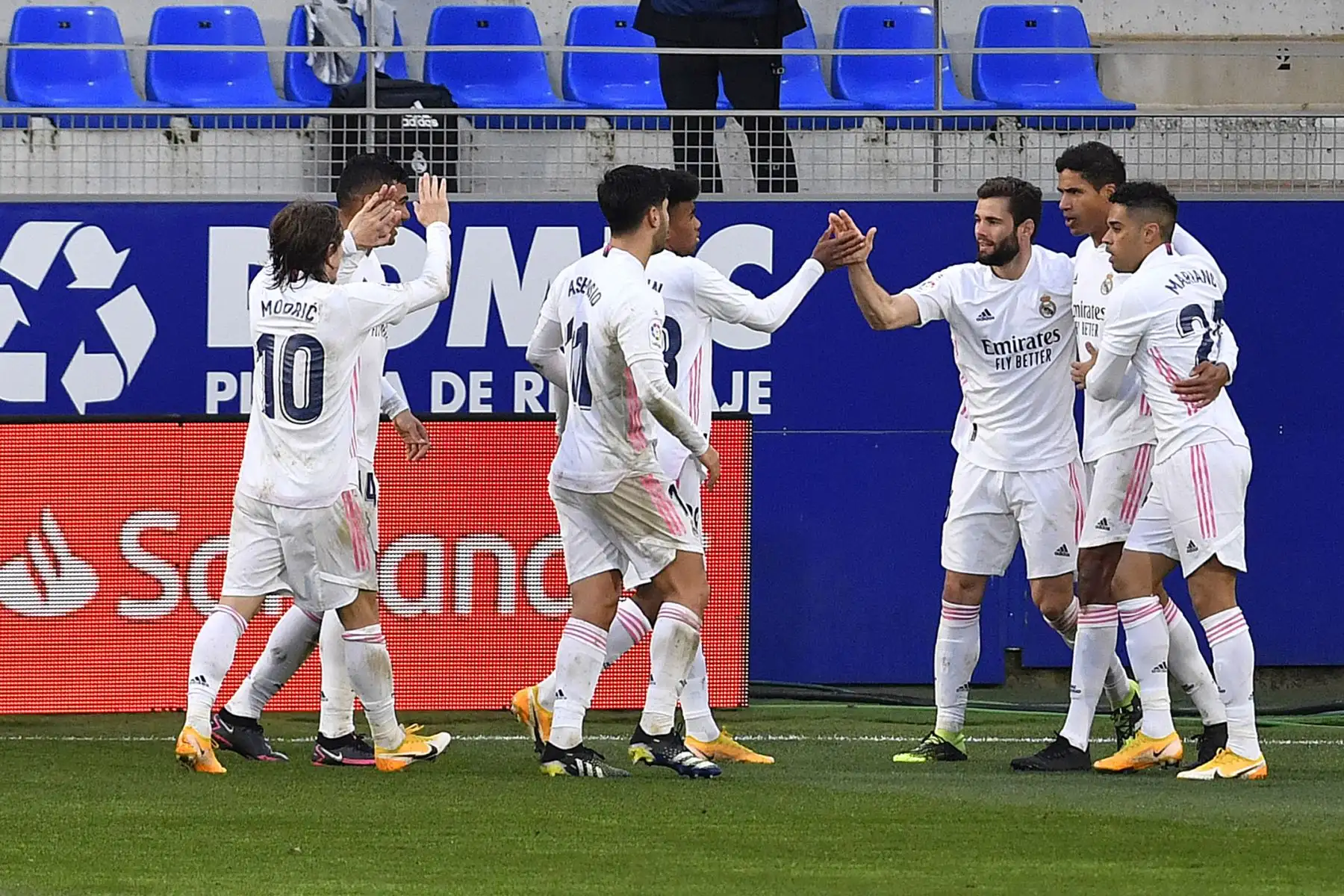 El defensa francés del Real Madrid Raphael Varane  celebra con sus compañeros tras marcar un segundo gol durante el partido de fútbol de la liga española entre la SD Huesca y el Real Madrid en el estadio El Alcoraz.
Foto: AFP