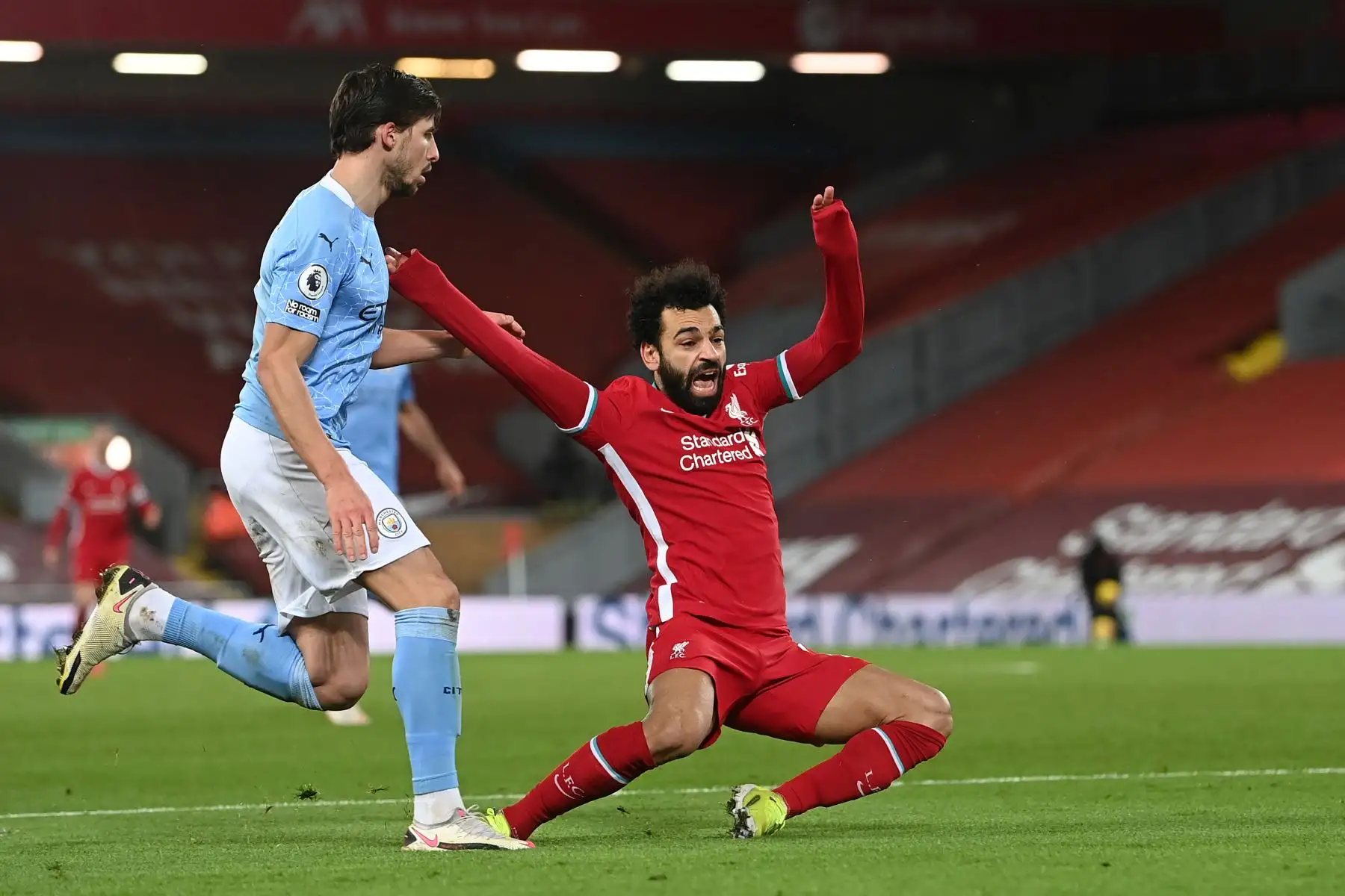 El defensor portugués del Manchester City Ruben Dias comete una falta al mediocampista egipcio del Liverpool Mohamed Salah para conceder un penalti durante el partido de fútbol de la Premier League inglesa entre Liverpool y Manchester City en Anfield en Liverpool.
Foto: AFP