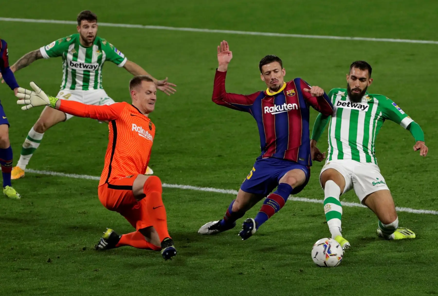 El delantero Borja Iglesias, del Real Betis Balompié, intenta el remate ante el francés Clement Lenglet y el alemán Marc-André Ter Stegen, portero del FC Barcelona, ​​en el partido correspondiente a la jornada 22 de La Liga Santander. Foto: EFE
