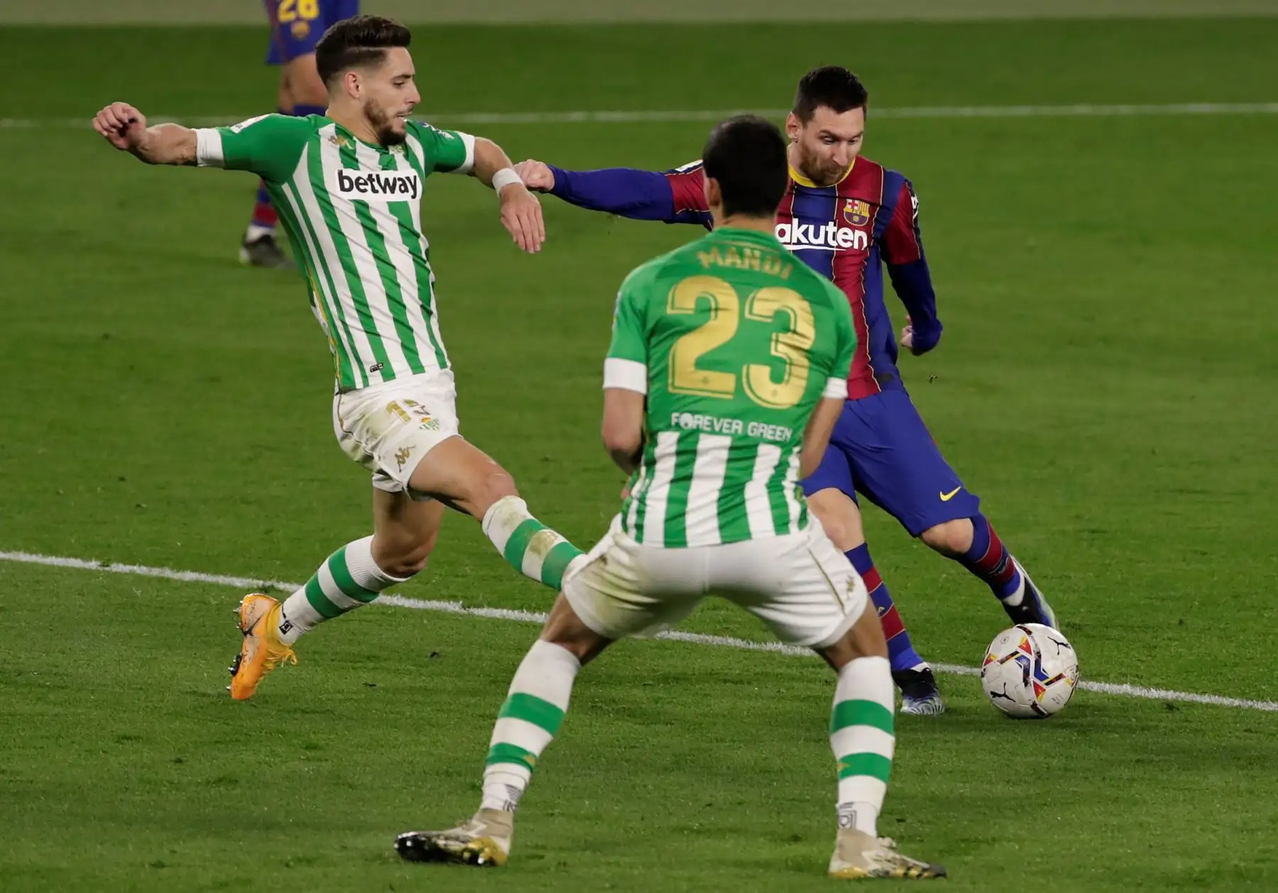 El argentino Lionel Messi, del FC Barcelona, ​​dispara entre Álex Moreno  y Aissa Mandi, ambos del Real Betis Balompié, para marcar el gol del empate, durante el partido correspondiente a la jornada 22 de La Liga Santander. Foto: EFE