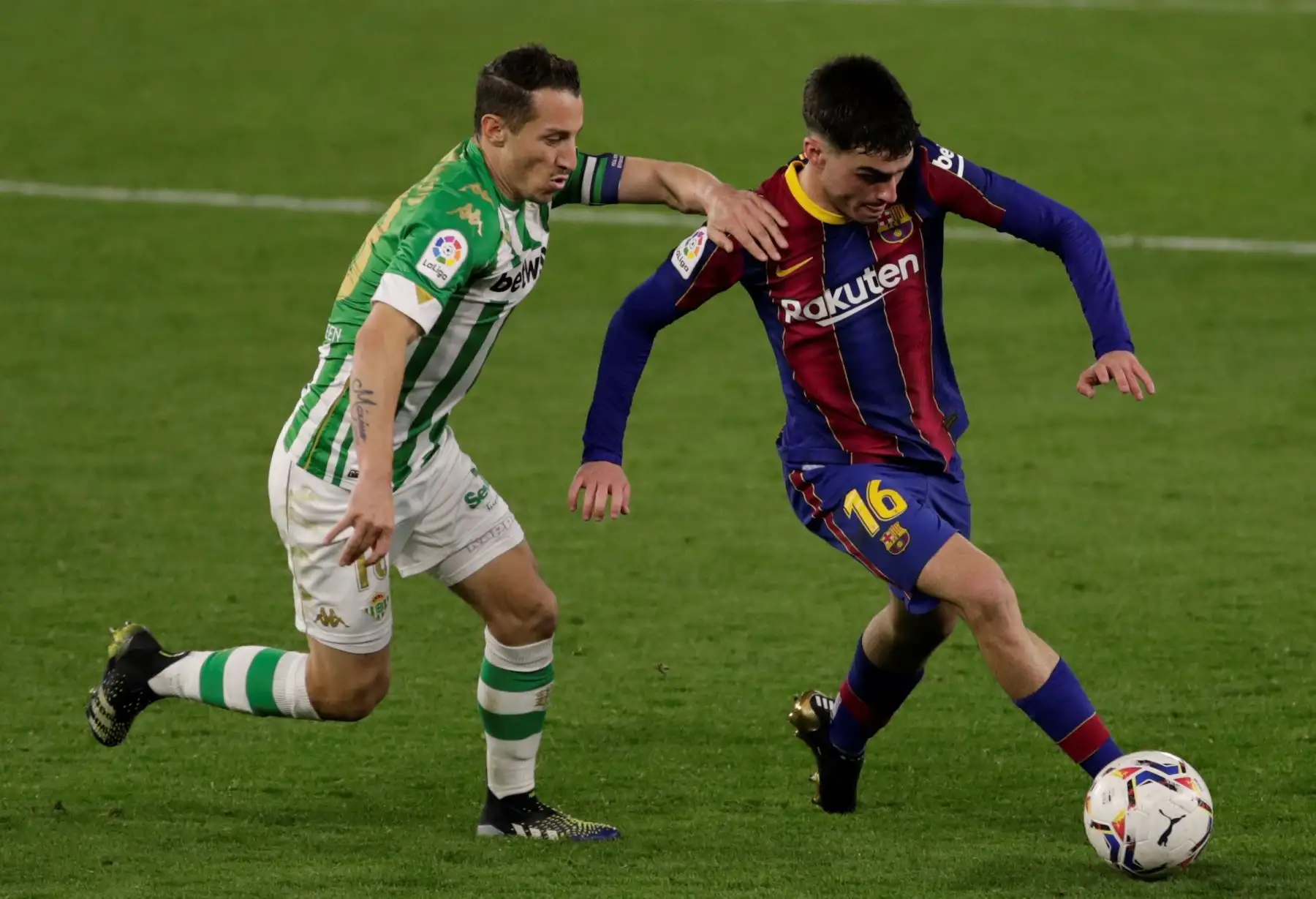 El centrocampista mexicano del Real Betis Balompié Andrés Guardado persigue a Pedro González "Pedri", del FC Barcelona, durante el partido correspondiente a la jornada 22 de La Liga Santander en el estadio Benito Villamarín, en Sevilla. EFE/, en Sevilla. Foto. EFE
