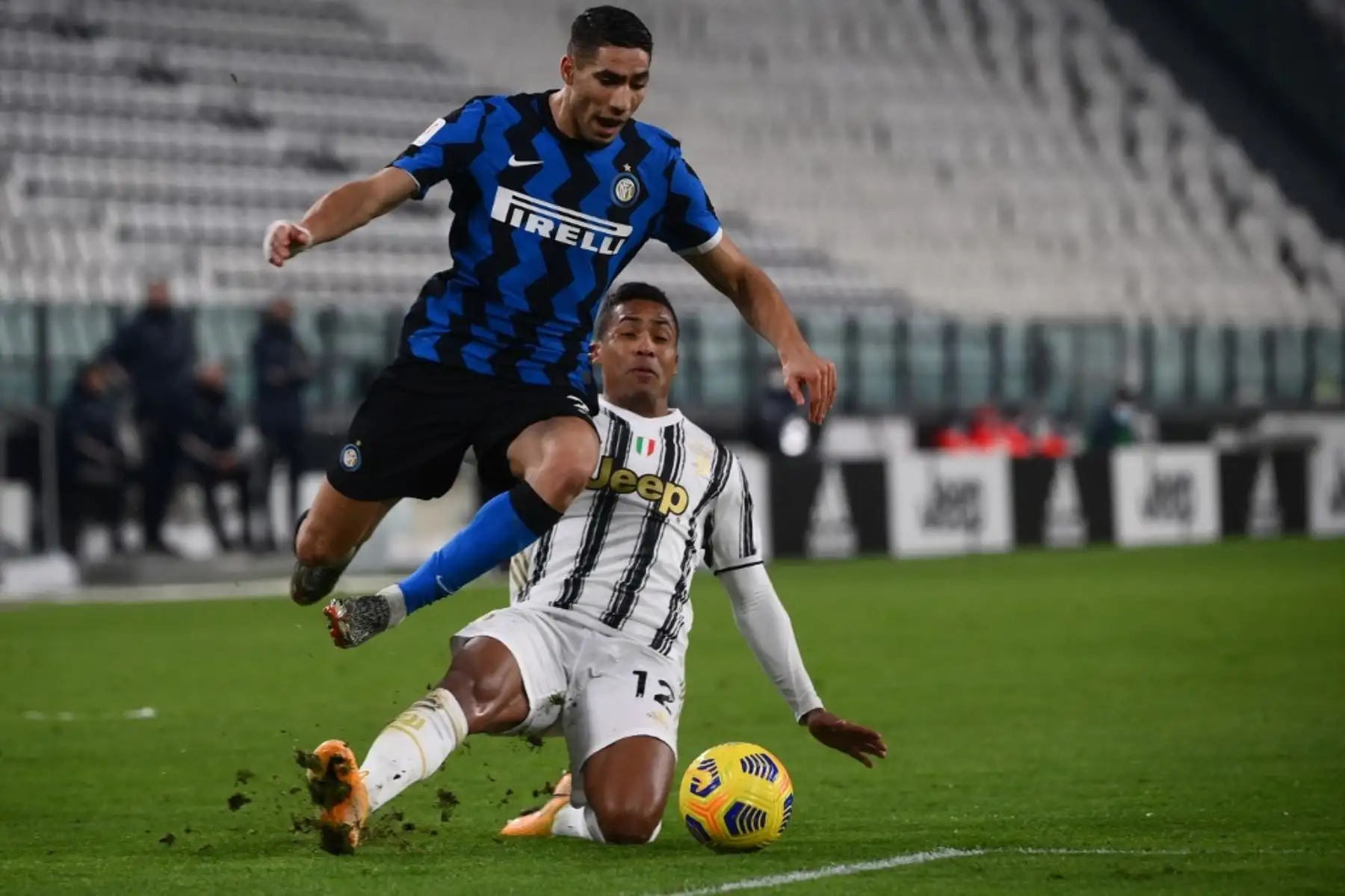 El defensa brasileño de la Juventus Alex Sandro aborda al defensa marroquí del Inter de Milán Achraf Hakimi en el límite del área de penalti durante el partido de vuelta de la semifinal de la Copa de Italia entre la Juventus de Turín y el Inter de Milán el 9 de febrero de 2021 en el estadio de la Juventus de Turín. Foto: AFP