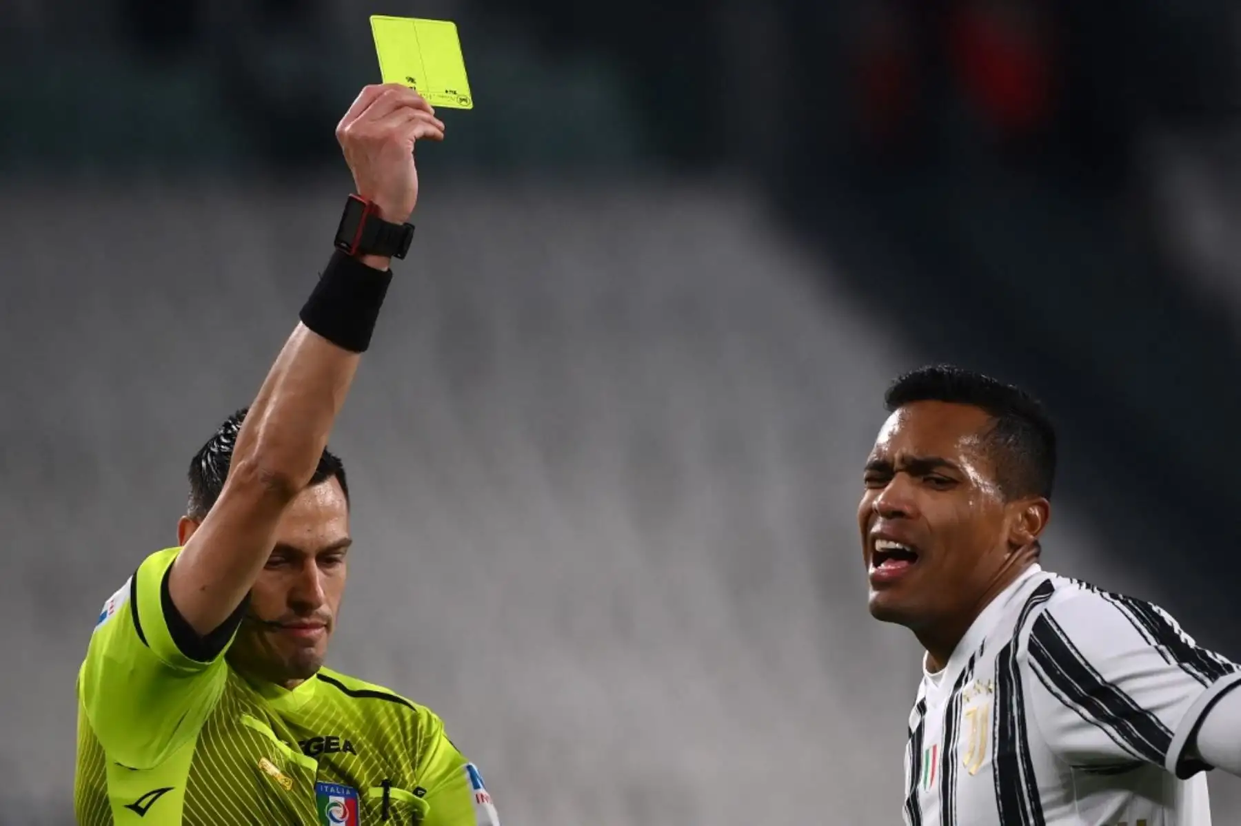 El árbitro italiano Maurizio Mariani da tarjeta amarilla al defensa brasileño de la Juventus Alex Sandro durante el partido de vuelta de la semifinal de la Copa de Italia entre la Juventus de Turín y el Inter de Milán el 9 de febrero de 2021 en el estadio de la Juventus de Turín. Foto: AFP