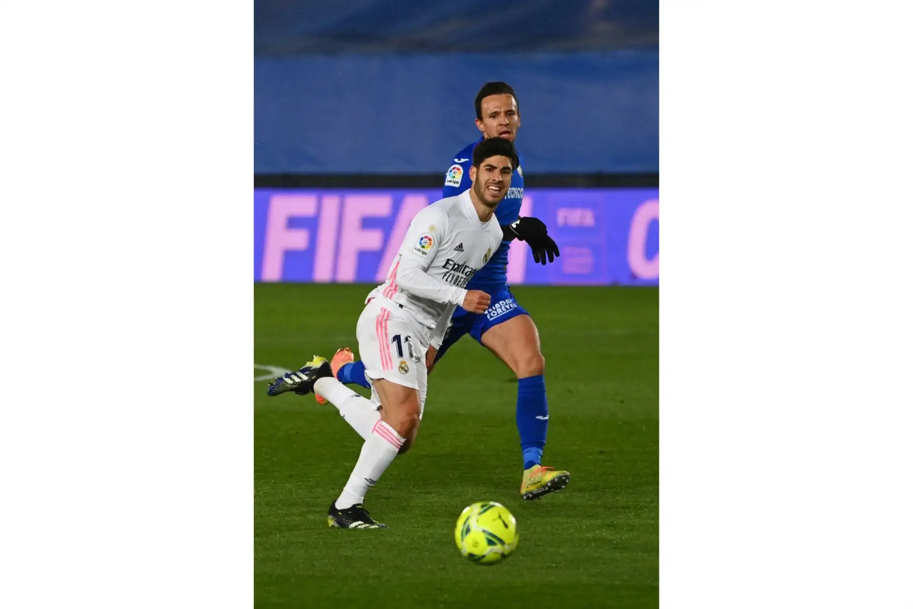 El centrocampista serbio del Getafe Nemanja Maksimovic reta al centrocampista español del Real Madrid Marco Asensio durante el partido de la liga española entre el Real Madrid CF y el Getafe CF en el estadio Alfredo di Stefano de Valdebebas, en las afueras de Madrid, el 9 de febrero de 2021. Foto: AFP