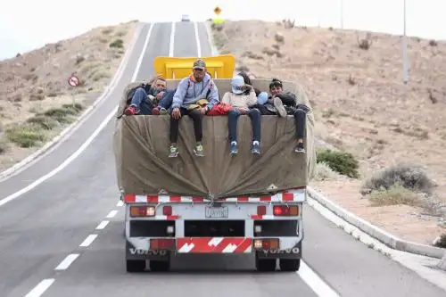 Migrantes venezolanos son vistos encima de un camión después de cruzar ilegalmente la frontera entre Bolivia y Chile en Colchane, Chile. Foto: AFP